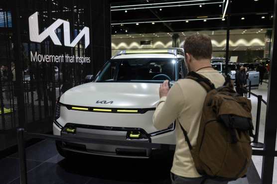 A visitor takes pictures of the Kia EV9 ADVNTR concept car during the AutoMobility LA 2024 auto show at the Los Angeles Convention Center in Los Angeles on November 21, 2024. (Photo by ETIENNE LAURENT / AFP)