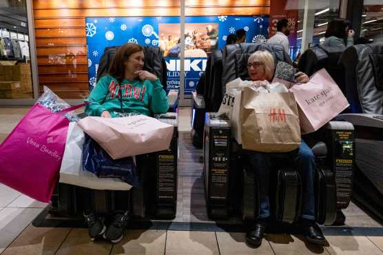 (FILES) Black Friday shoppers take a moment to rest in massage chairs at the Opry Mills Mall in Nashville, Tennessee, on November 25, 2022. US shoppers are coming out in force this 2024 holiday season, but the festiveness is being tempered by inflationary pressures that have abated but not completely faded. Americans are "ready to open their wallets this holiday season," said the Conference Board ahead of Black Friday -- the day after Thanksgiving, which this year, falls on November 28 -- that traditionally sees US stores kick off the Christmas shopping season with steep discounts. (Photo by SETH HERALD / AFP)