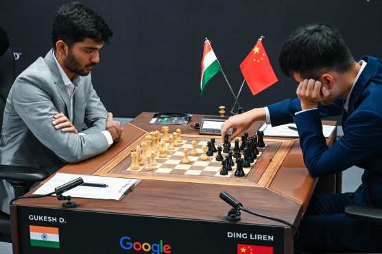 Chinas chess grandmaster Ding Liren (R) and Indias chess grandmaster Gukesh Dommaraju (L) compete during the start of the FIDE World Chess Championship in Singapore on November 25, 2024. (Photo by Roslan RAHMAN / AFP)