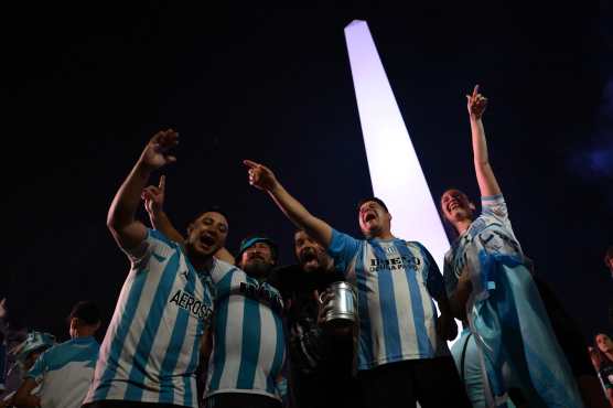 Fans of Racing celebrate the victory of their team in the Copa Sudamericana final football match between Argentina's Racing and Brazil's Cruzeiro, at the Obelisk in Buenos Aires, on November 23, 2024. (Photo by Luis ROBAYO / AFP)