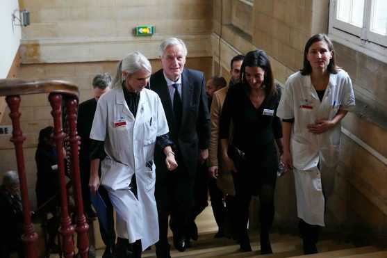 French Prime Minister Michel Barnier (3R) walks accompanied by medical staff during a visit at the "House of Women of the AP-HP" ("Maison des Femmes de l'Assistance Publique - Hopitaux de Paris") in Paris, on November 25, 2024 as part of the International Day for the Elimination of Violence Against Women. (Photo by Dimitar DILKOFF / AFP)