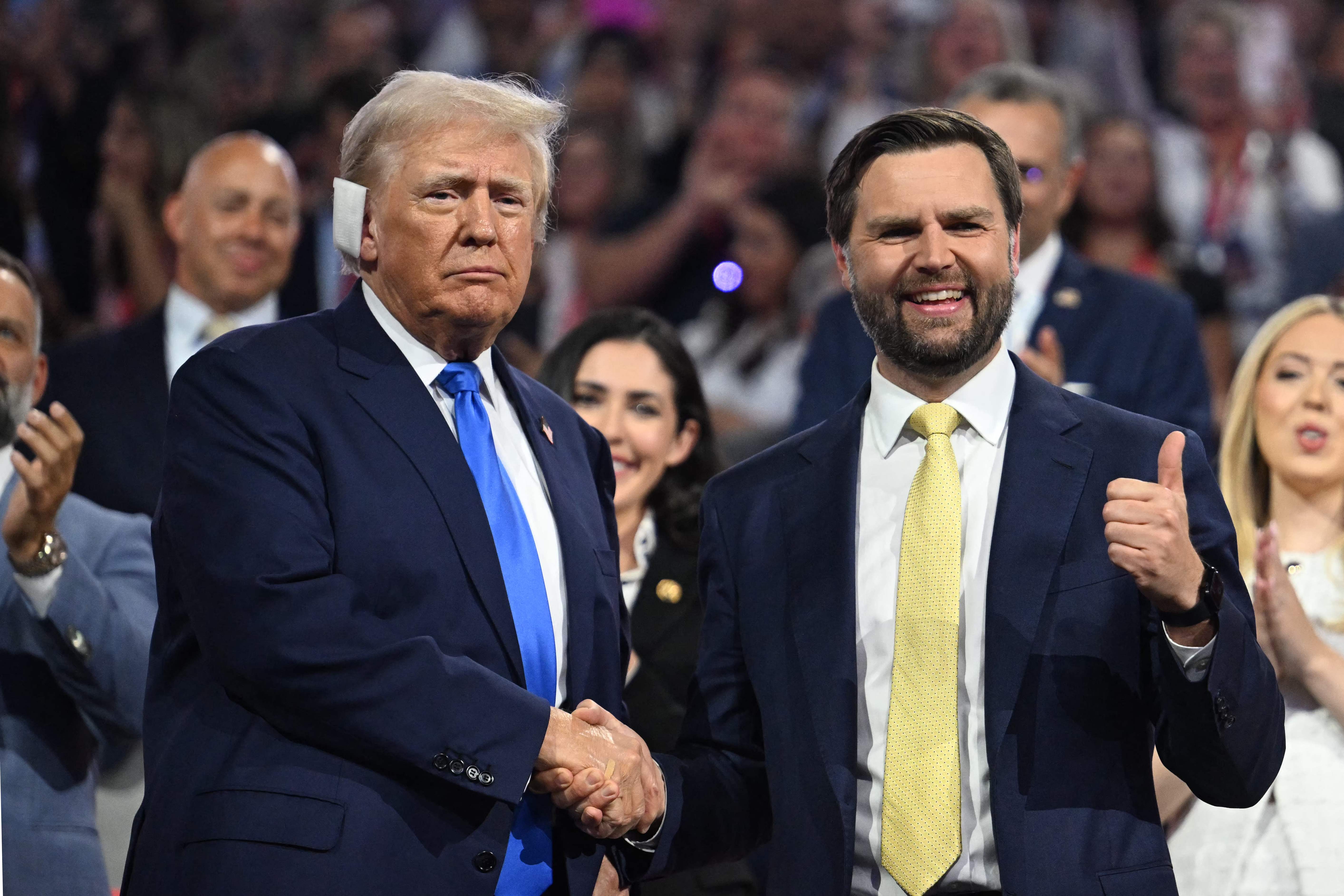 (FILES) US Senator from Ohio and 2024 Republican vice presidential candidate J.D. Vance (R) gives a thumbs up as he shakes hands with US former President and 2024 Republican presidential candidate Donald Trump during the second day of the 2024 Republican National Convention at the Fiserv Forum in Milwaukee, Wisconsin, July 16, 2024. Kamala Harris and Donald Trump are entering the final one-month sprint to the most dramatic US presidential election in modern history, with both candidates warning the fate of a divided nation hangs on a result that is still too close to call. (Photo by Jim WATSON / AFP)