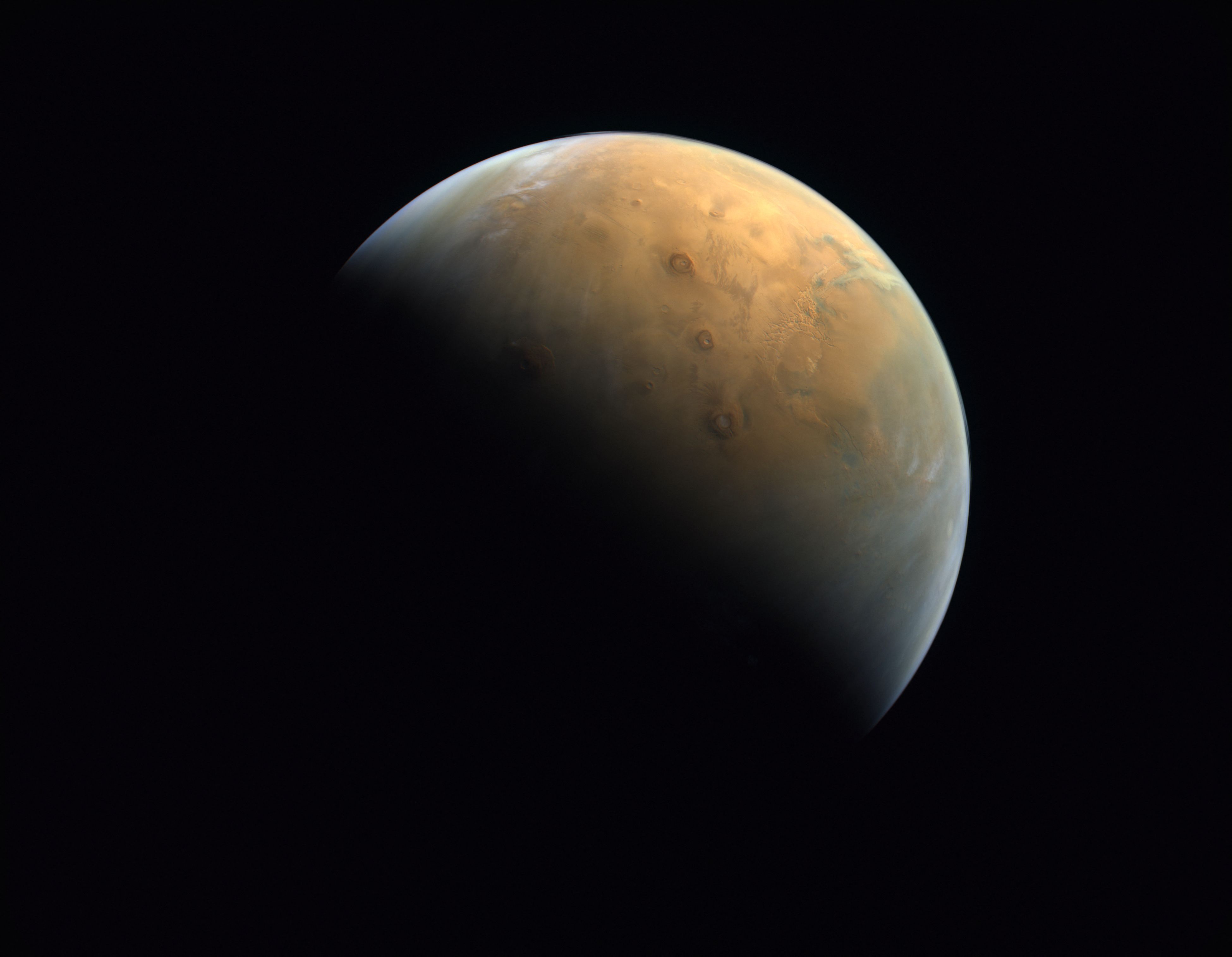 (FILES) A handout picture provided on February 14, 2021 by the United Arab Emirates Space Agency (UAESA) taken by the Emirates eXploration Imager (EXI) after Mars Orbit Insertion (MOI) on board the First Emirates Mars Mission (EMM) from an altitude of 24,700 km above the Martian surface shows the Olympus Mons, the highest volcano on Mars, and the Tharsis Montes, three volcanoes named (top to bottom) Ascraeus Mons, Pavonis Mons and Arsia Mons. A Chinese rover has found new evidence to support the theory that Mars was once home to a vast ocean, including tracing some ancient coastline where water may once have lapped, a study said on November 7, 2024. (Photo by United Arab Emirates Space Agency / AFP)