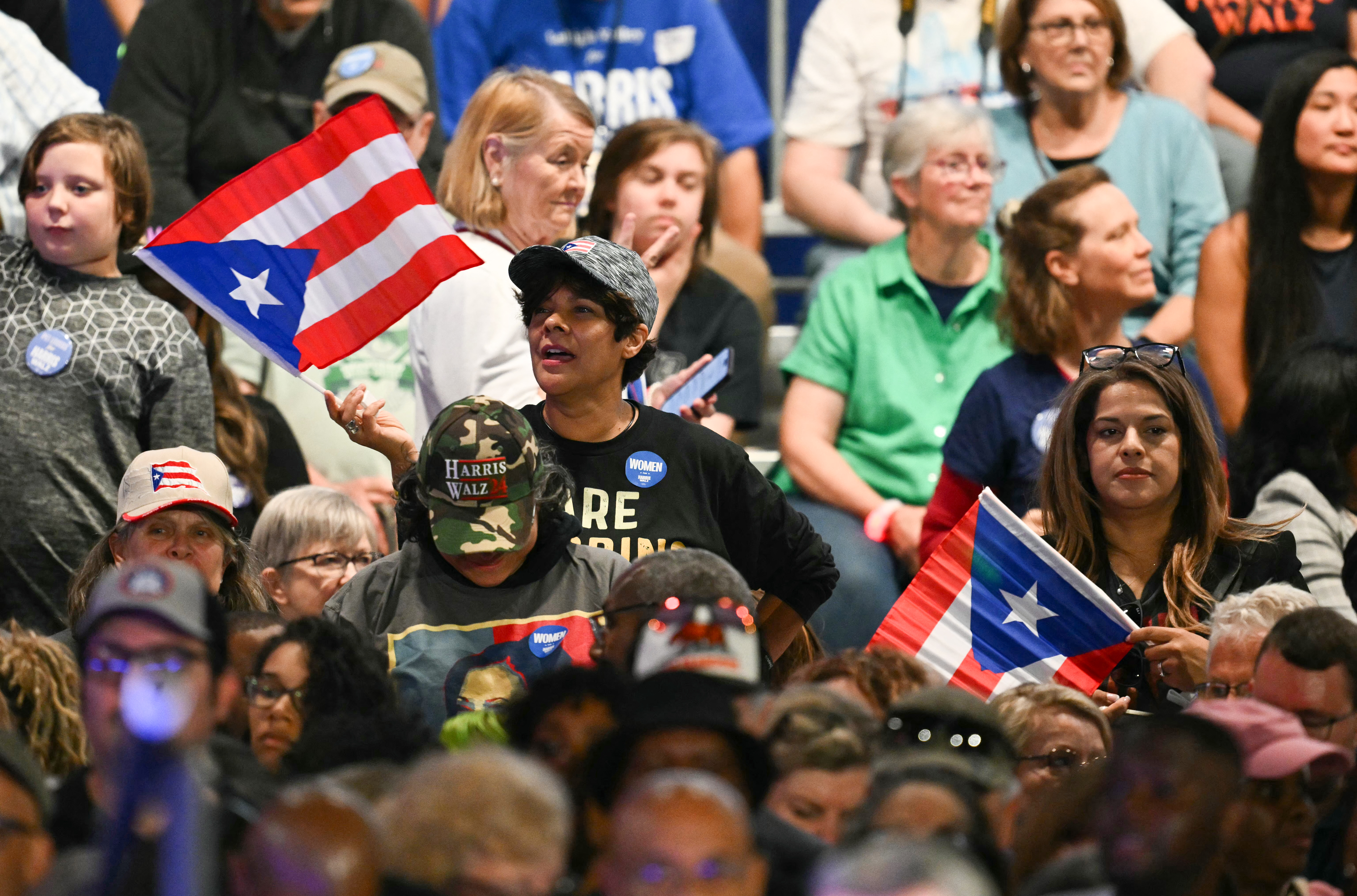 Supporters wave Puerto Rico flags as US Vice President and Democratic presidential candidate Kamala Harris speaks during a Get Out the Vote rally at the Pennsylvania Farm Show Complex & Expo Center in Harrisburg, Pennsylvania, on October 30, 2024. (Photo by ANGELA WEISS / AFP)