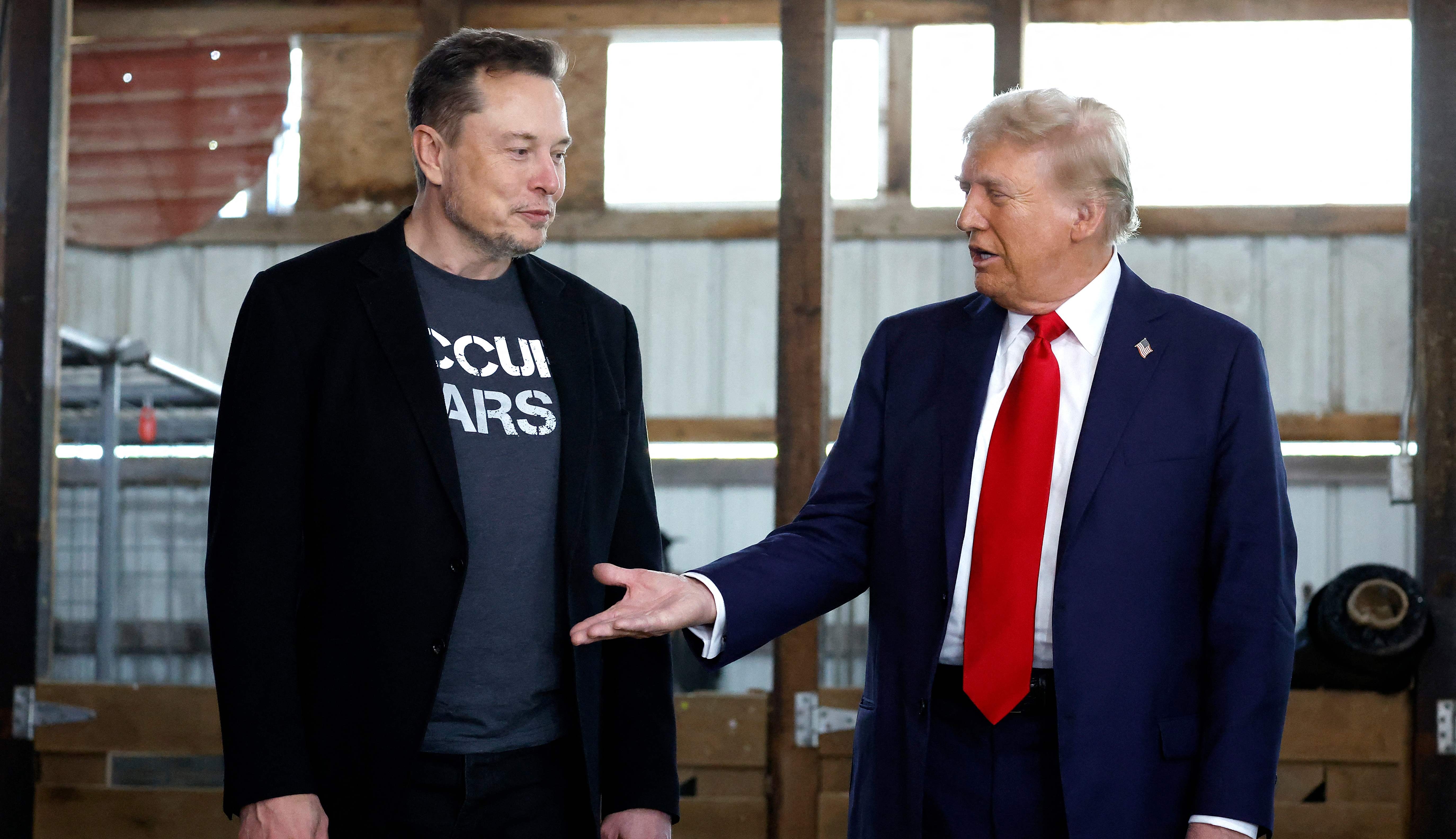 BUTLER, PENNSYLVANIA - OCTOBER 05: Republican presidential nominee, former President Donald Trump offers his hand to Elon Musk back stage during a campaign rally at the Butler Farm Show grounds on October 05, 2024 in Butler, Pennsylvania. This is the first time that Trump has returned to Butler since he was injured during an attempted assassination on July 13.   Anna Moneymaker/Getty Images/AFP (Photo by Anna Moneymaker / GETTY IMAGES NORTH AMERICA / Getty Images via AFP)