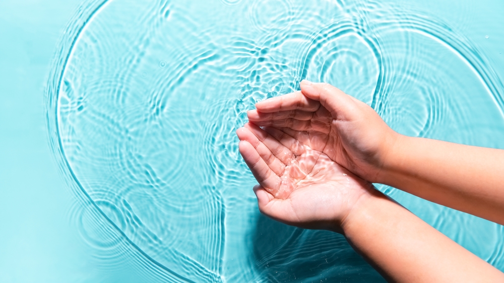 Mujer lavando manos limpiando por ambas manos pureza agua transparente espacio de fondo azul de agua. Higiene del estilo de vida de la gente naturaleza médica bienestar protector. Día Mundial del Medio Ambiente Día Mundial del Agua