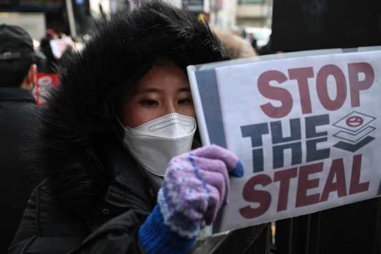 A Pro-Yoon supporter holds a placard outside the Seoul Western District Court in Seoul on January 18, 2025, as the court weighs whether to extend the detention of impeached South Korea President Yoon Suk Yeol, after investigators arrested him over a failed martial law bid. Yoon, who has claimed his arrest and investigation is illegal, threw the nation into chaos on December 3 when he attempted to suspend civilian rule, citing the need to combat threats from "anti-state elements". (Photo by JUNG Yeon-je / AFP)