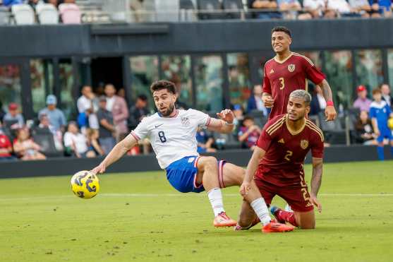 US forward #8 Brian White shoots on goal as Venezuelan defender #2 Carlos Vivas tries to block the shot during the USA against Venezuela international friendly at Chase Stadium in Fort Lauderdale, Florida, on January 18, 2025. (Photo by Chris Arjoon / AFP)