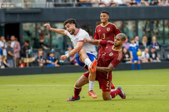 US forward #8 Brian White shoots on goal as Venezuelan defender #2 Carlos Vivas tries to block the shot during the USA against Venezuela international friendly at Chase Stadium in Fort Lauderdale, Florida, on January 18, 2025. (Photo by Chris Arjoon / AFP)