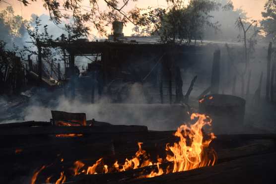 Flames are seen on burning vegetation are seen during a forest fire in San Miguel, Asuncion on January 18, 2025. (Photo by DANIEL DUARTE / AFP)