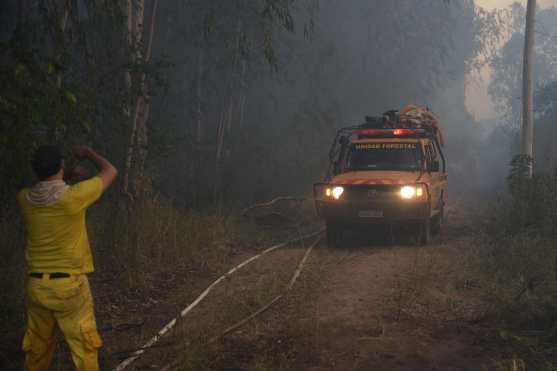 Firefighters in a pickup truck are seen during a forest fire in San Miguel, Asuncion on January 18, 2025. (Photo by DANIEL DUARTE / AFP)