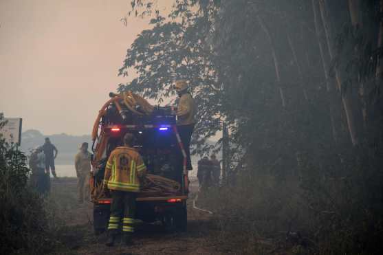 Firefighters in a pickup truck are seen during a forest fire in San Miguel, Asuncion on January 18, 2025. (Photo by DANIEL DUARTE / AFP)