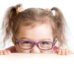 niño asustado con espectáculos mirando desde el escritorio de la mesa