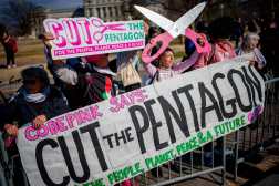 WASHINGTON, DC - FEBRUARY 25: Protesters with the group CodePink hold up signs that read "Cut the Pentagon" during a Congressional DOGE Caucus news conference on Capitol Hill on February 25, 2025 in Washington, DC. The newly formed Department of Government Efficiency (DOGE) Caucus held a news conference on "DOGE Day" to unveil member initiatives "aimed at cutting waste and improving government efficiency."   Andrew Harnik/Getty Images/AFP (Photo by Andrew Harnik / GETTY IMAGES NORTH AMERICA / Getty Images via AFP)