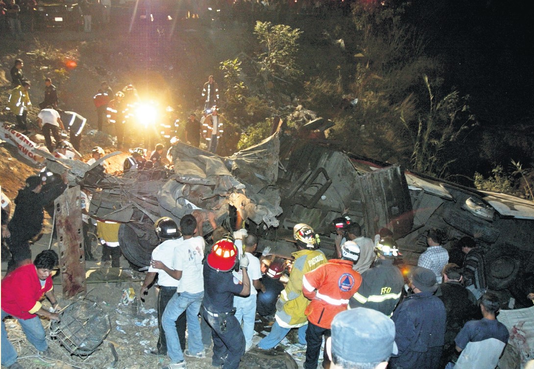 Los cuerpos de socorro rescatan de entre los restos del autobús los cuerpos de pasajeros, en el kilómetro 33.5, vuelta El Chilero, el 29 de febrero de 2008. (Foto Prensa Libre: HemerotecaPL)