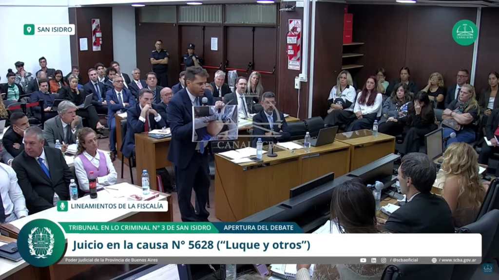 Captura de pantalla de un video de la Suprema Corte de la Provincia de Buenos Aires del fiscal general adjunto del tribunal de San Isidro, Patricio Ferrari, mostrando una foto durante la primera audiencia del juicio sobre el fallecimiento de Diego Armando Maradona postrado en una cama y tomada en el contexto de su muerte.