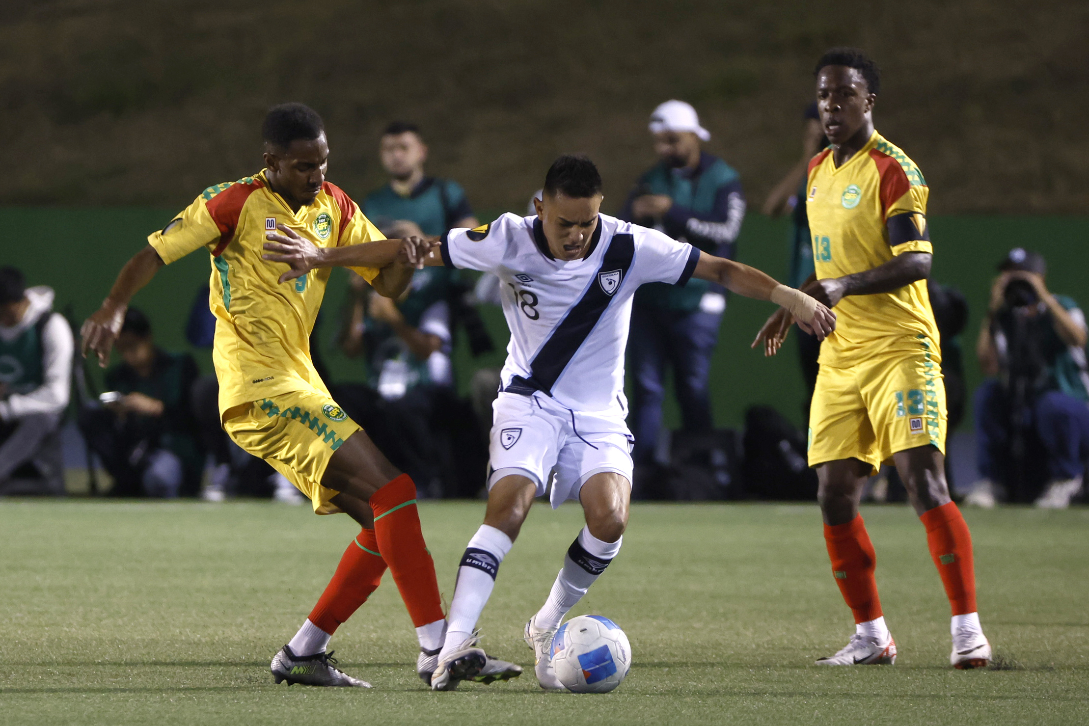 Óscar Santiz de Guatemala disputa un balón con Isaiah Jones de Guyana.