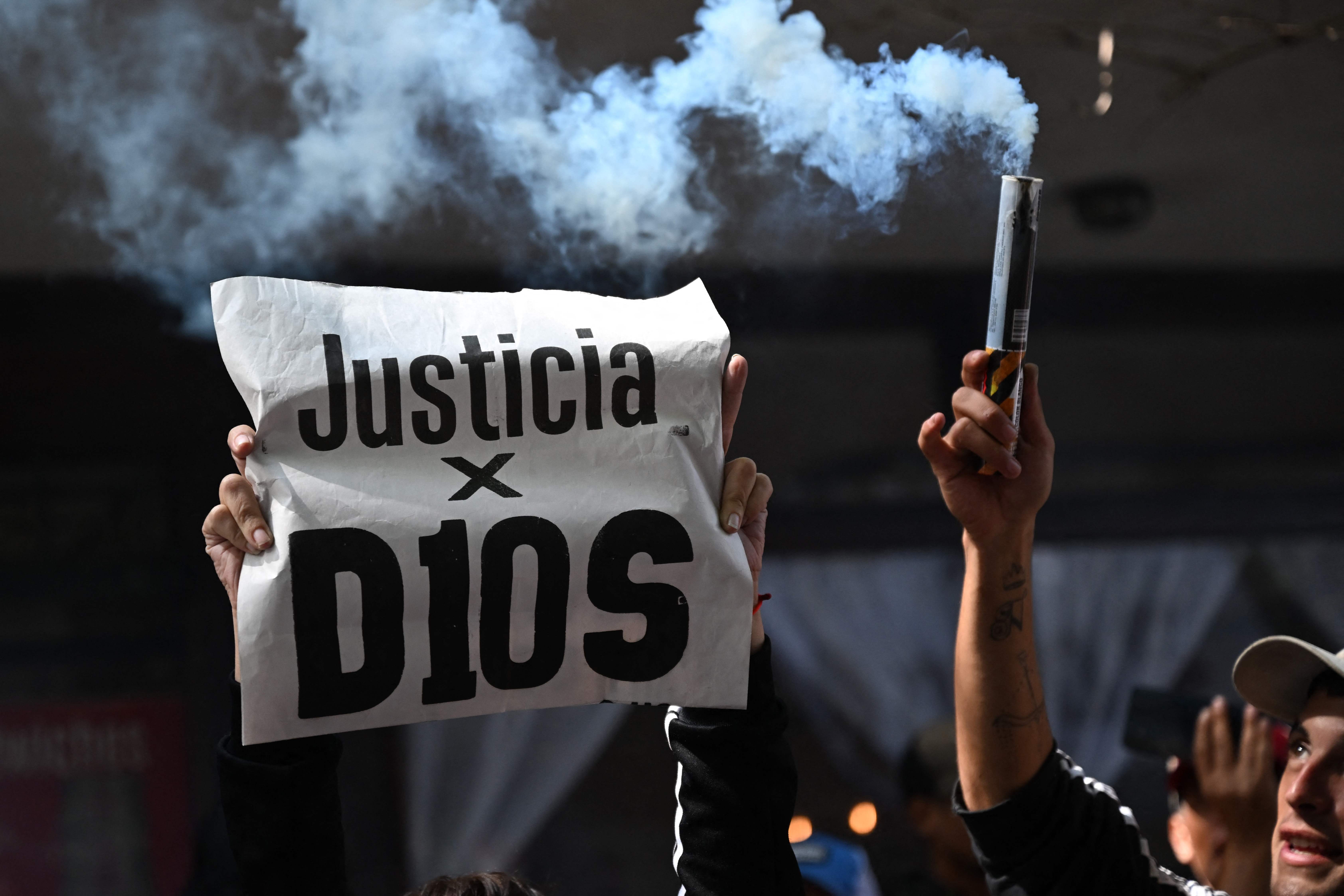 Un aficionado sostiene un cartel que dice 'Justicia para D10s' durante el juicio por la muerte de Diego Maradona.'