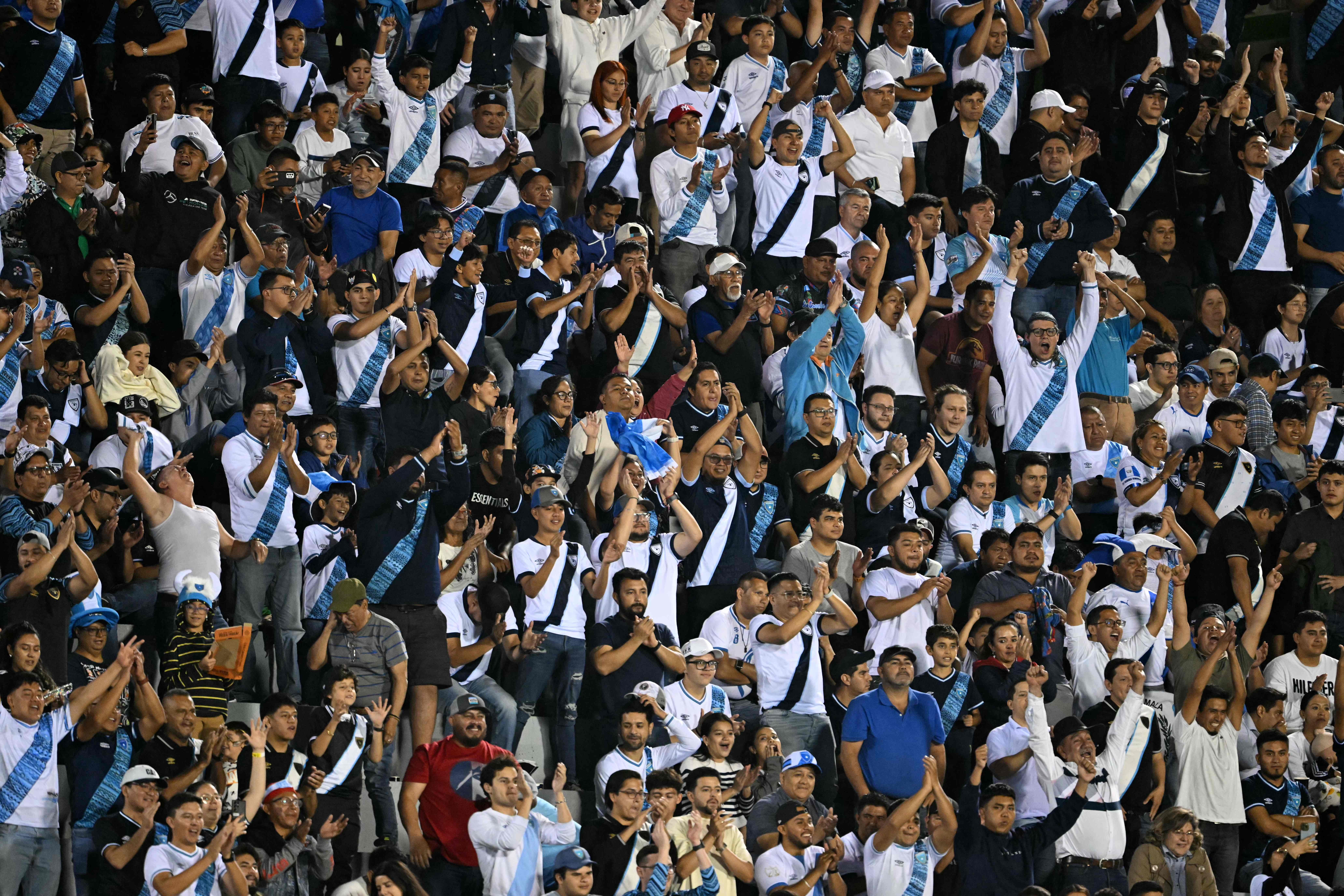 Aficionados de Guatemala animan a su selección durante el partido de clasificación para la Copa Oro de la CONCACAF entre Guatemala y Guyana en el estadio Cemento Progreso de la Ciudad de Guatemala, el 25 de marzo de 2025.
