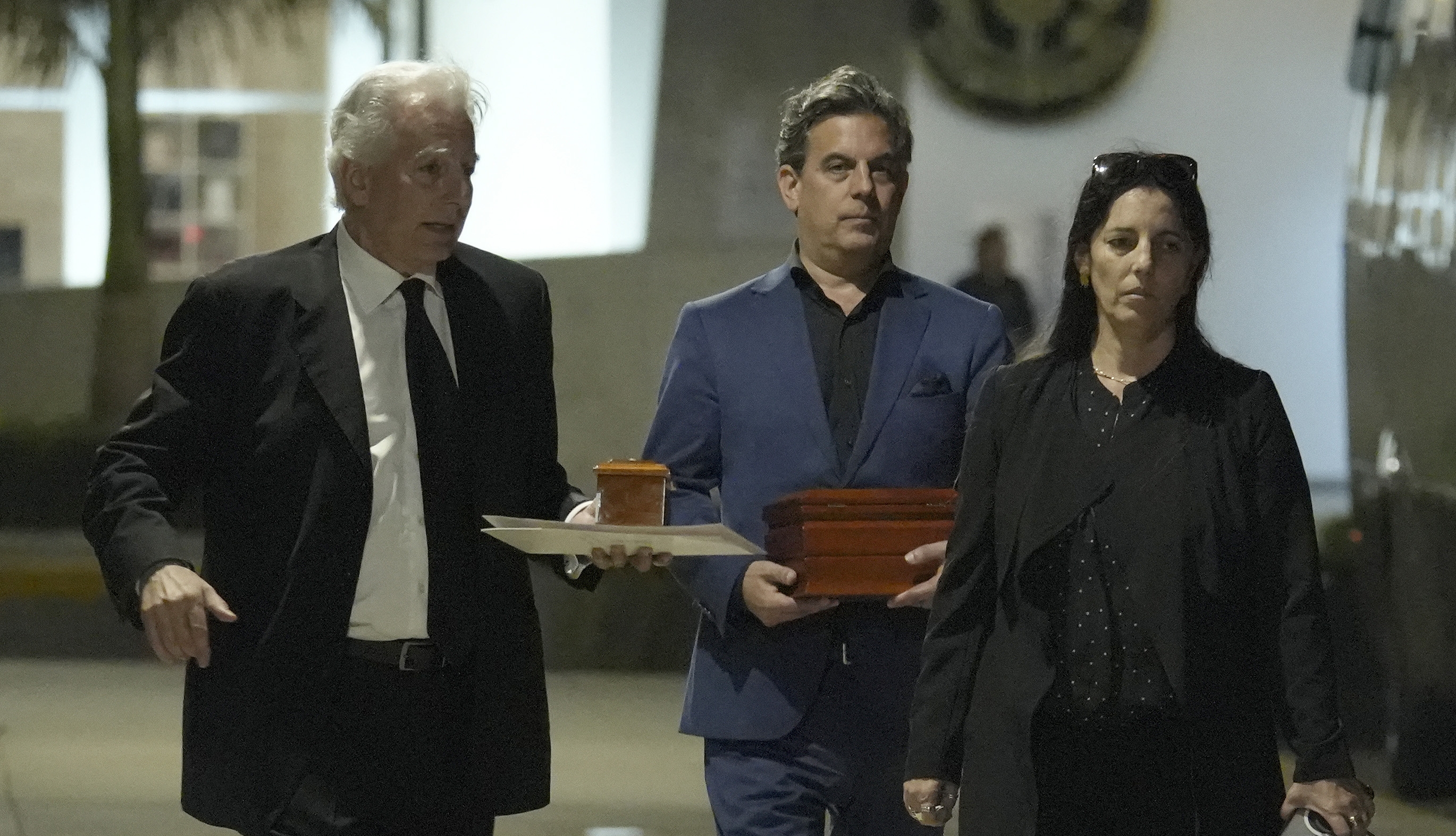 AME9582. LIMA (PERÚ), 14/04/2025.- De izquierda a derecha, Álvaro Vargas Llosa, Gonzalo Vargas Llosa y Morgana Vargas Llosa, hijos del escritor peruano Mario Vargas Llosa, caminan portando dos urnas con los restos de su padre afuera del Centro Funerario y Crematorio del Ejército de Chorrillos este lunes, en Lima (Perú). Los restos del escritor peruano Mario Vargas Llosa fueron cremados en una ceremonia íntima, tal y como deseaba el Nobel de Literatura de 2010, en el Centro Funerario y Crematorio del Ejército de Chorrillos, a donde fueron trasladados desde su casa en Lima, y entregados a sus tres hijos: Álvaro, Gonzalo y Morgana. EFE/ John Reyes Mejía