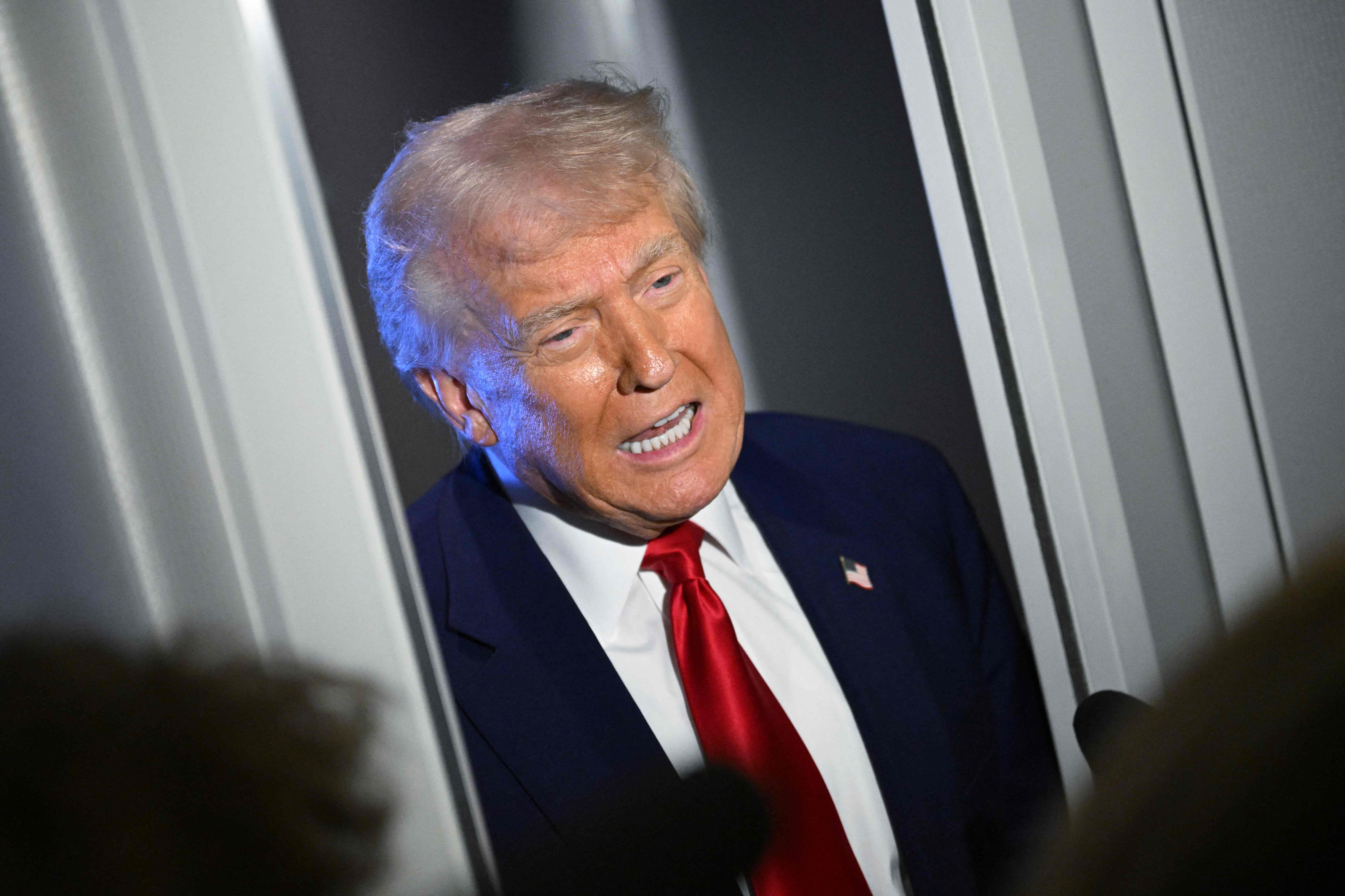 US President Donald Trump speaks to reporters while in flight on board Air Force One, en route to Miami, Florida on April 3, 2025. Trump is travelling to the Trump National Doral Golf Club before going to his Mar-a-Lago Resort. (Photo by MANDEL NGAN / AFP)