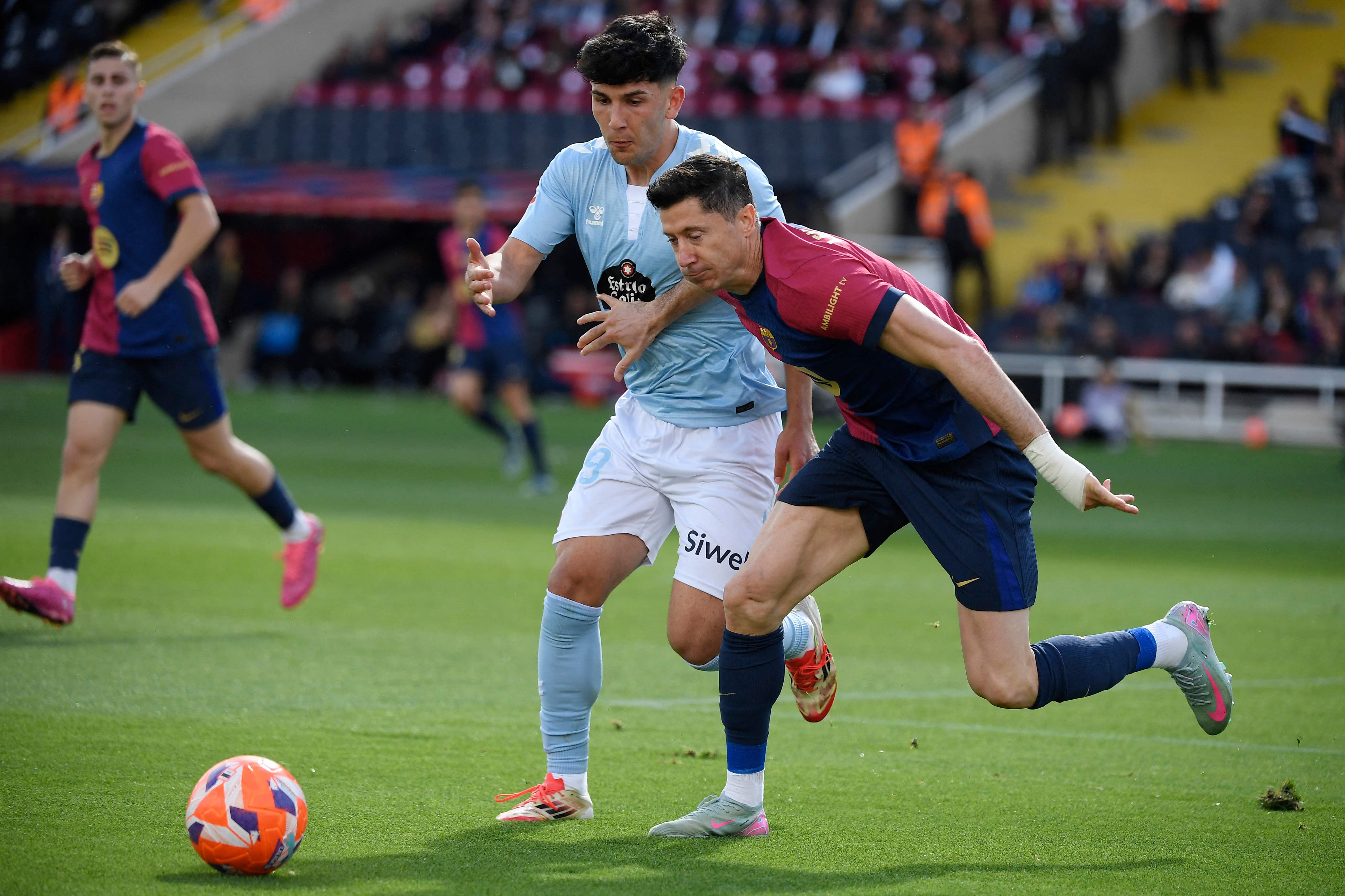 Celta Vigo's Spanish defender #29 Yoel Lago (L) and Barcelona's Polish forward #09 Robert Lewandowski vie for the ball during the Spanish league football match between FC Barcelona and RC Celta de Vigo at the Estadi Olimpic Lluis Companys in Barcelona on April 19, 2025. (Photo by Josep LAGO / AFP)