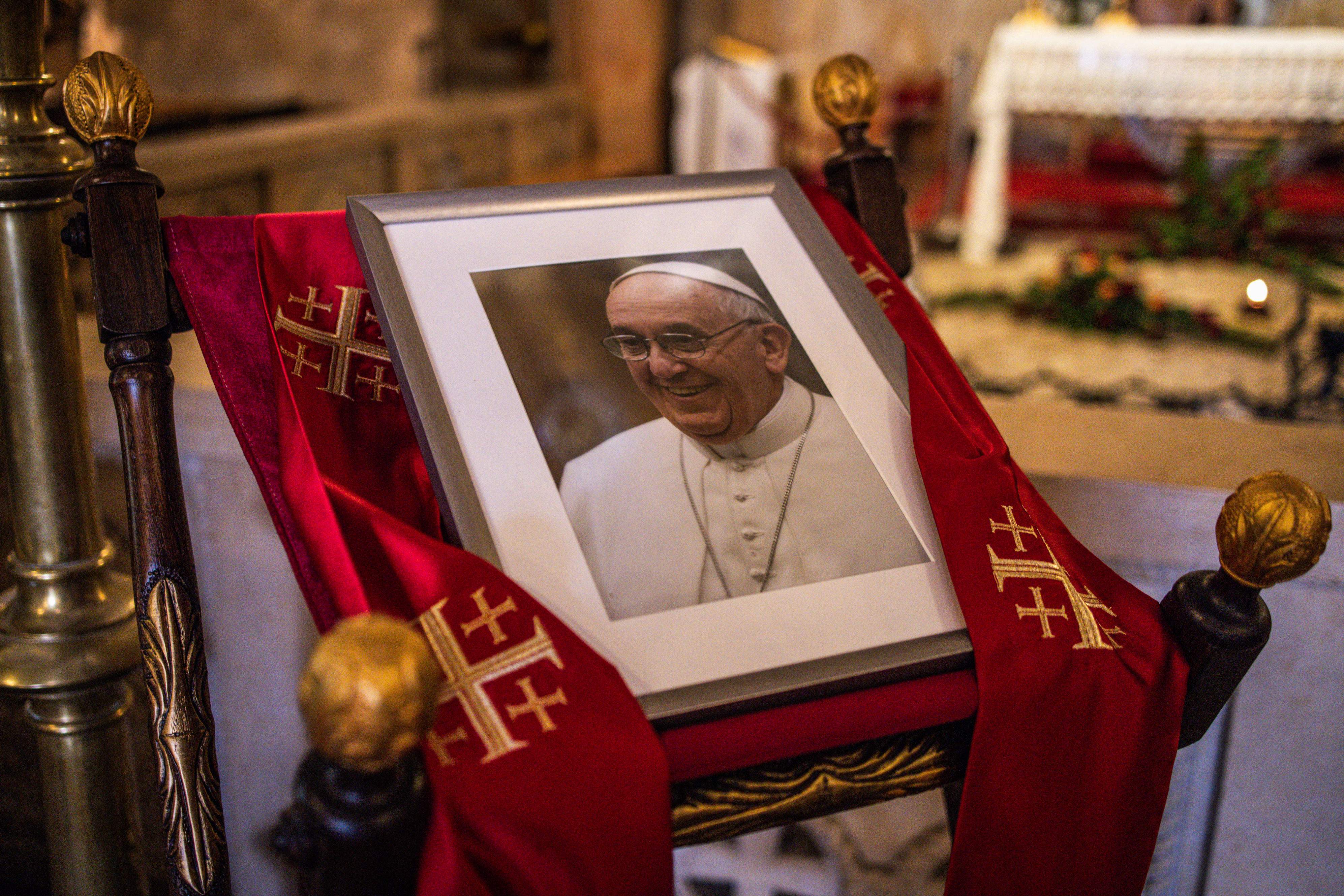 A portrait of late Pope Francis is displayed in the Franciscan Church in the Old City of Jerusalem on April 21, 2025. Pope Francis, who will go down in history as a radical pontiff and a champion of underdogs, died on April 21 at age 88, having forged a more compassionate Catholic Church. (Photo by JOHN WESSELS / AFP)
