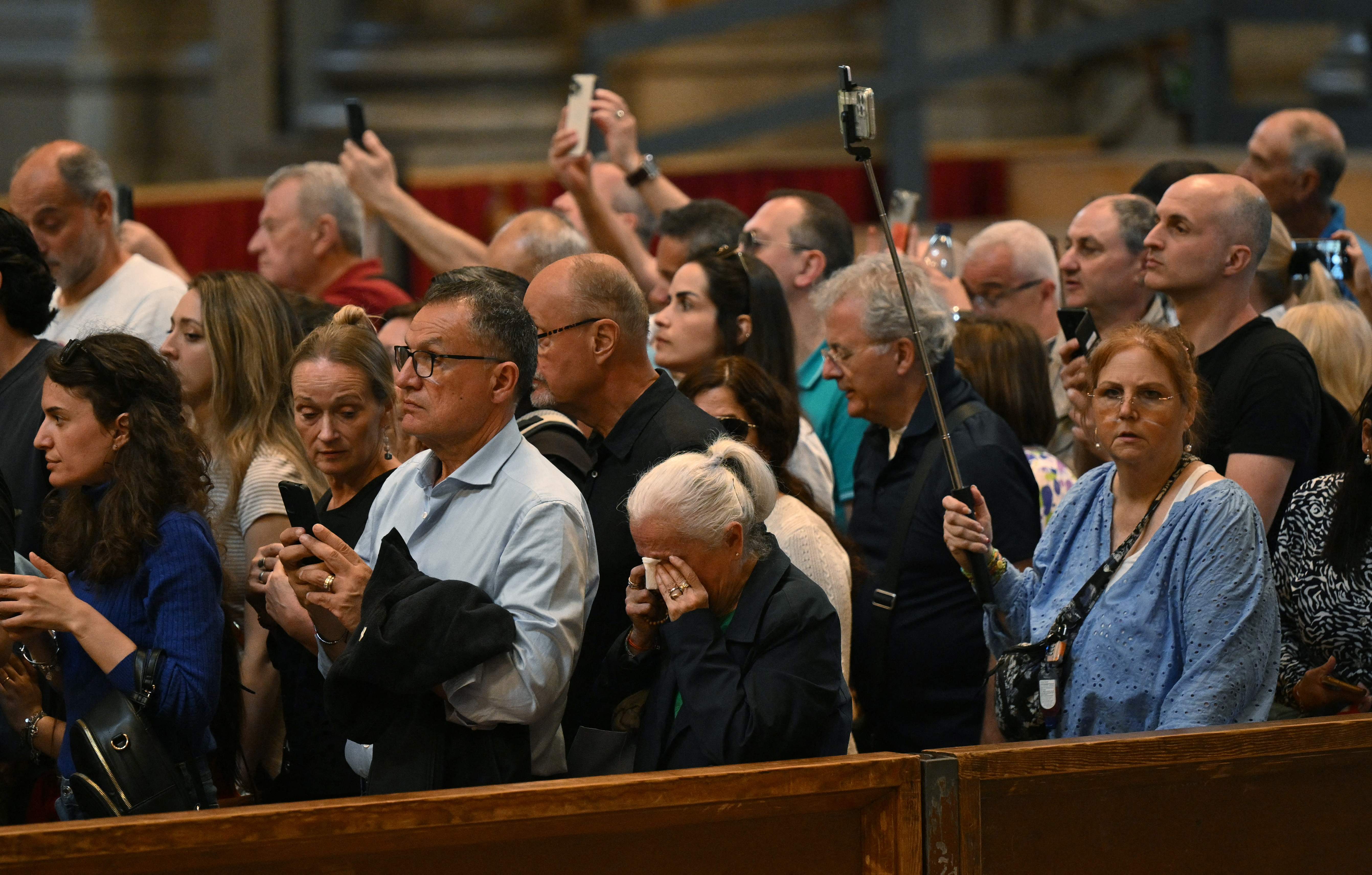 Fieles que se despiden del papa Francisco critican a personas que se toman "selfies" con el ataúd del pontífice. (Foto Prensa Libre: Andrej ISAKOVIC / AFP)