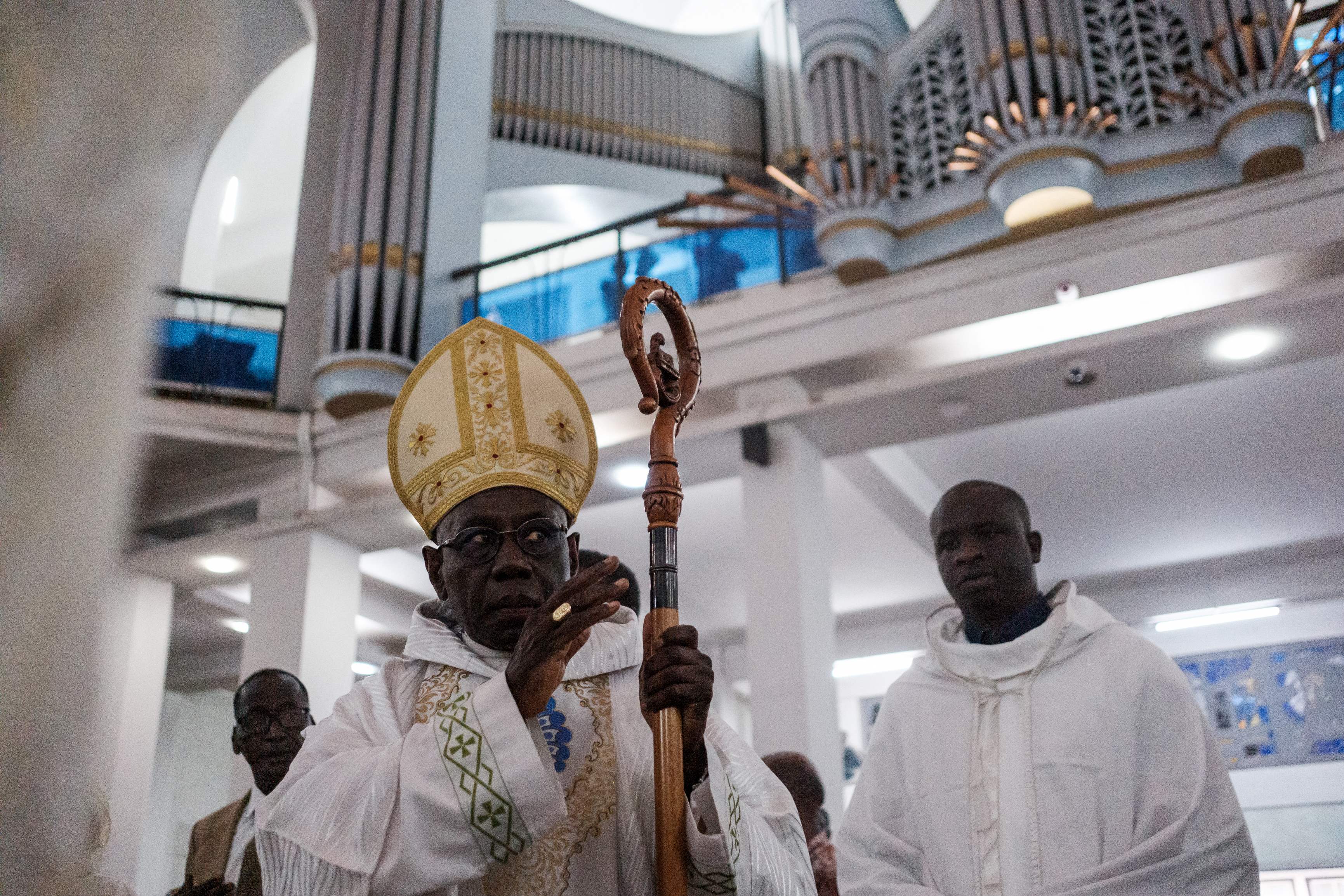 (FILES) Guinean cardinal Robert Sarah (L) attends a prayer at the Cathedral of Our Lady of Victories in Dakar on December 4, 2023. As Africa's share of the Catholic population booms, mirroring its growing share of the world population as the continent grows while Europe has greyed and secularised, renewed attention has turned to whether the church is ready for its first black pope. (Photo by GUY PETERSON / AFP)