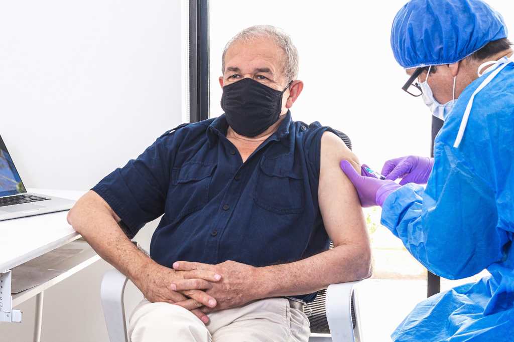 Adultos mayores que reciben la vacuna del coronavirus en un hospital por un médico durante la pandemia. Concepto de campaña de vacunación