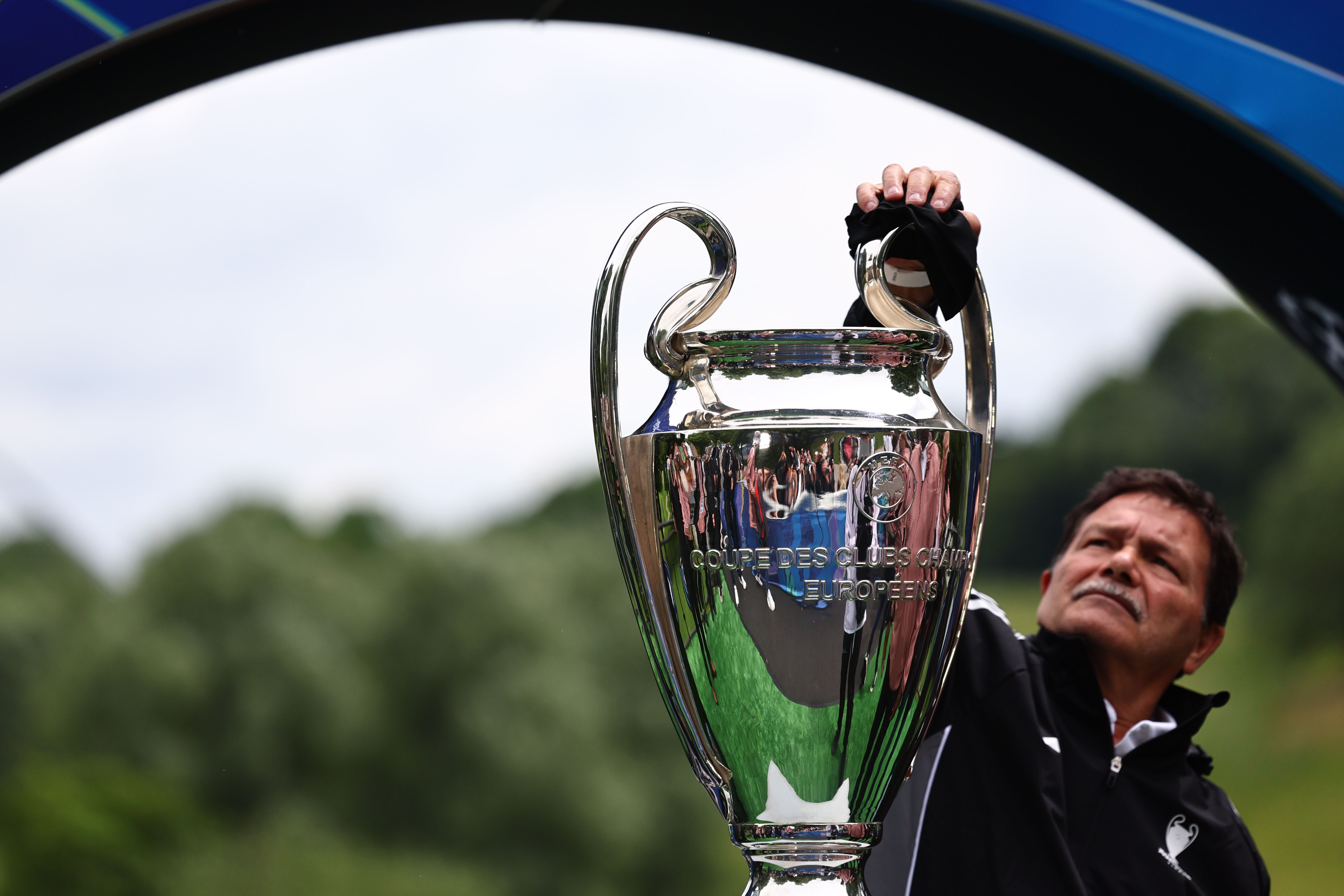 Un hombre limpia el trofeo de la Liga de Campeones durante el festival de la UEFA, en el Parque Olímpico de Múnich, Alemania.