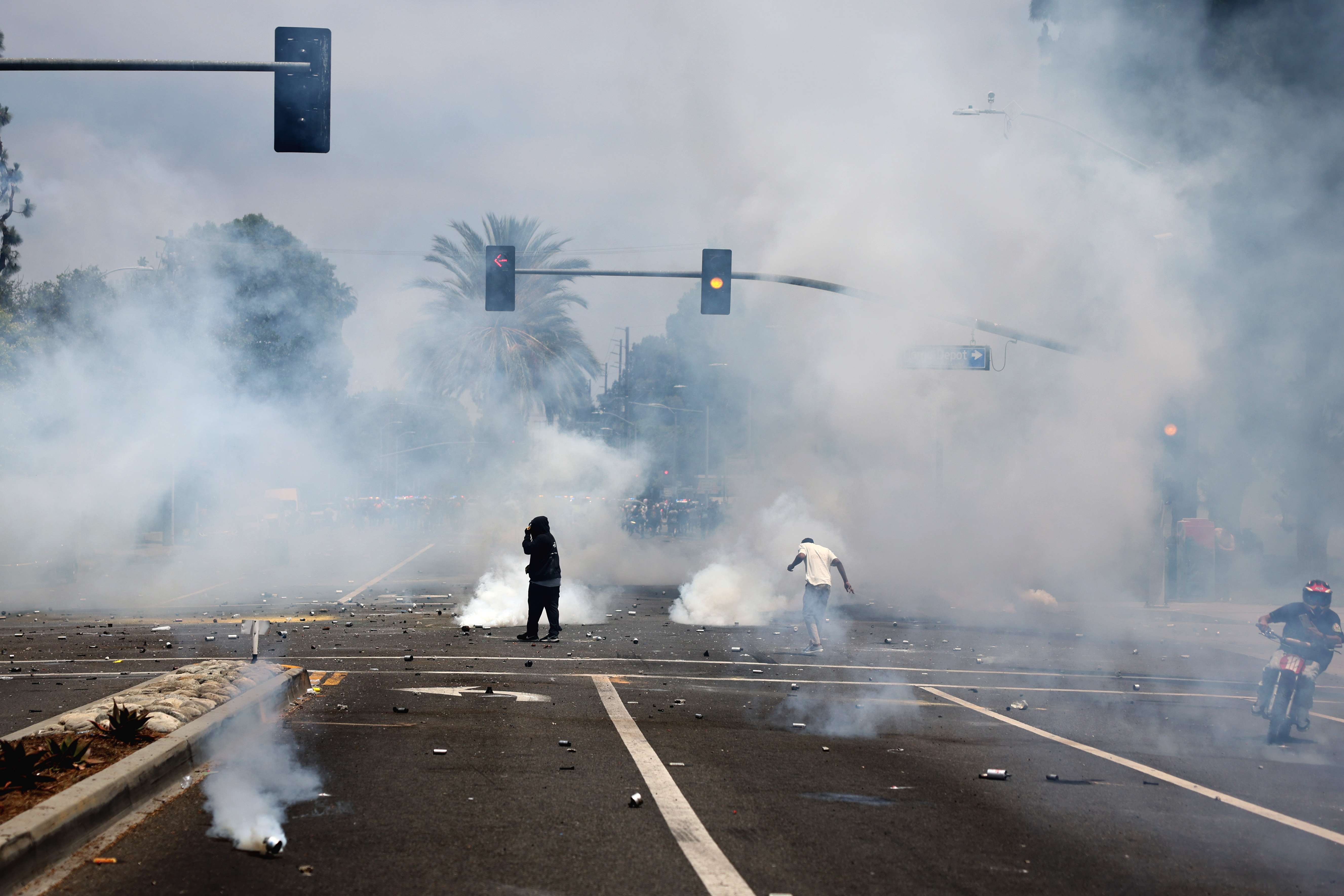 Manifestantes corren entre gases lacrimógenos disparados por agentes federales cerca de un Home Depot luego de una redada realizada por el Servicio de Inmigración y Control de Aduanas (ICE) en Paramount, California, EE.UU. (Foto Prensa Libre: EFE).