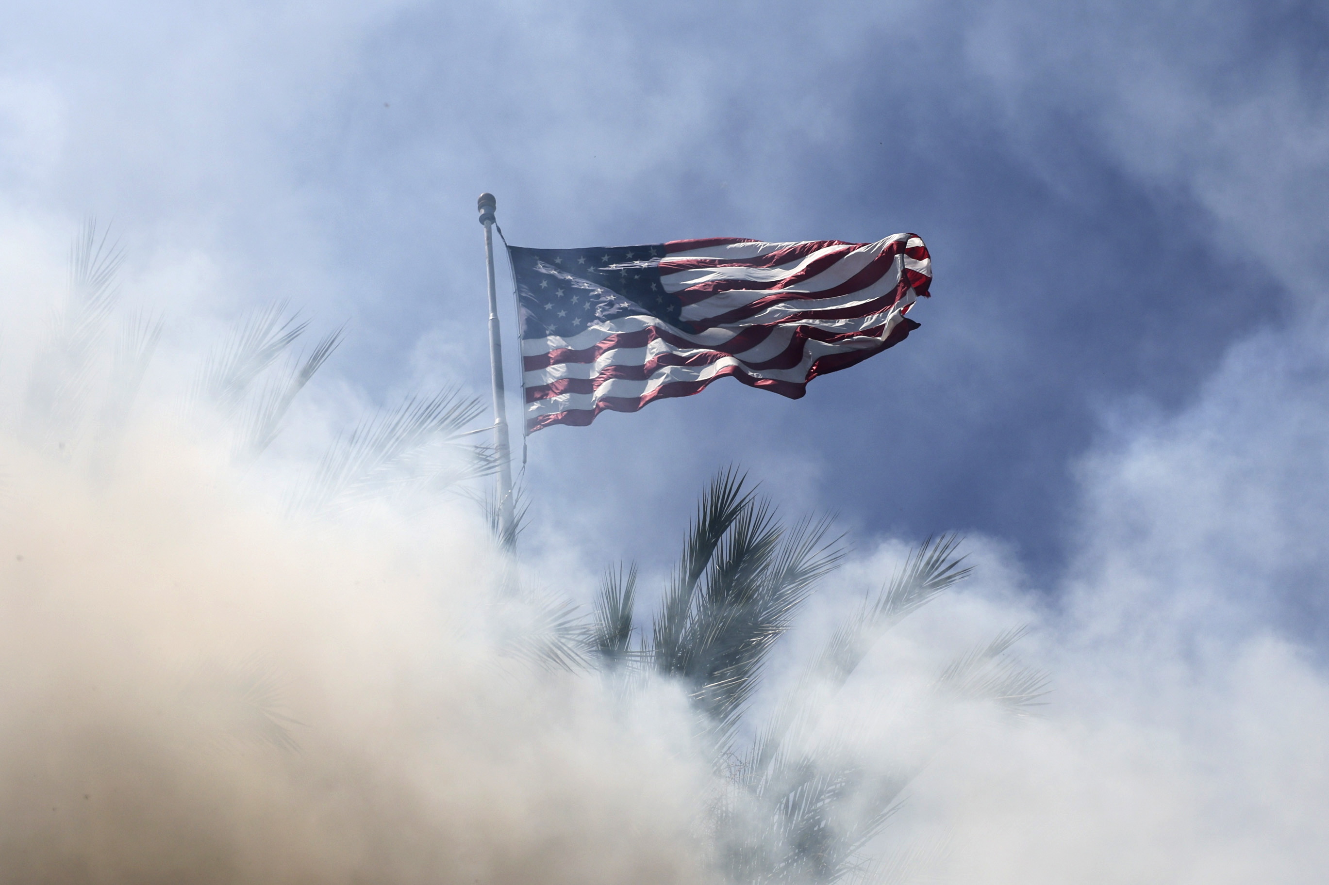 La bandera de Estados Unidos cubierta por gas en medio de los disturbios en Paramount, Los Ángeles, California, EE.UU. (Foto Prensa Libre: EFE)