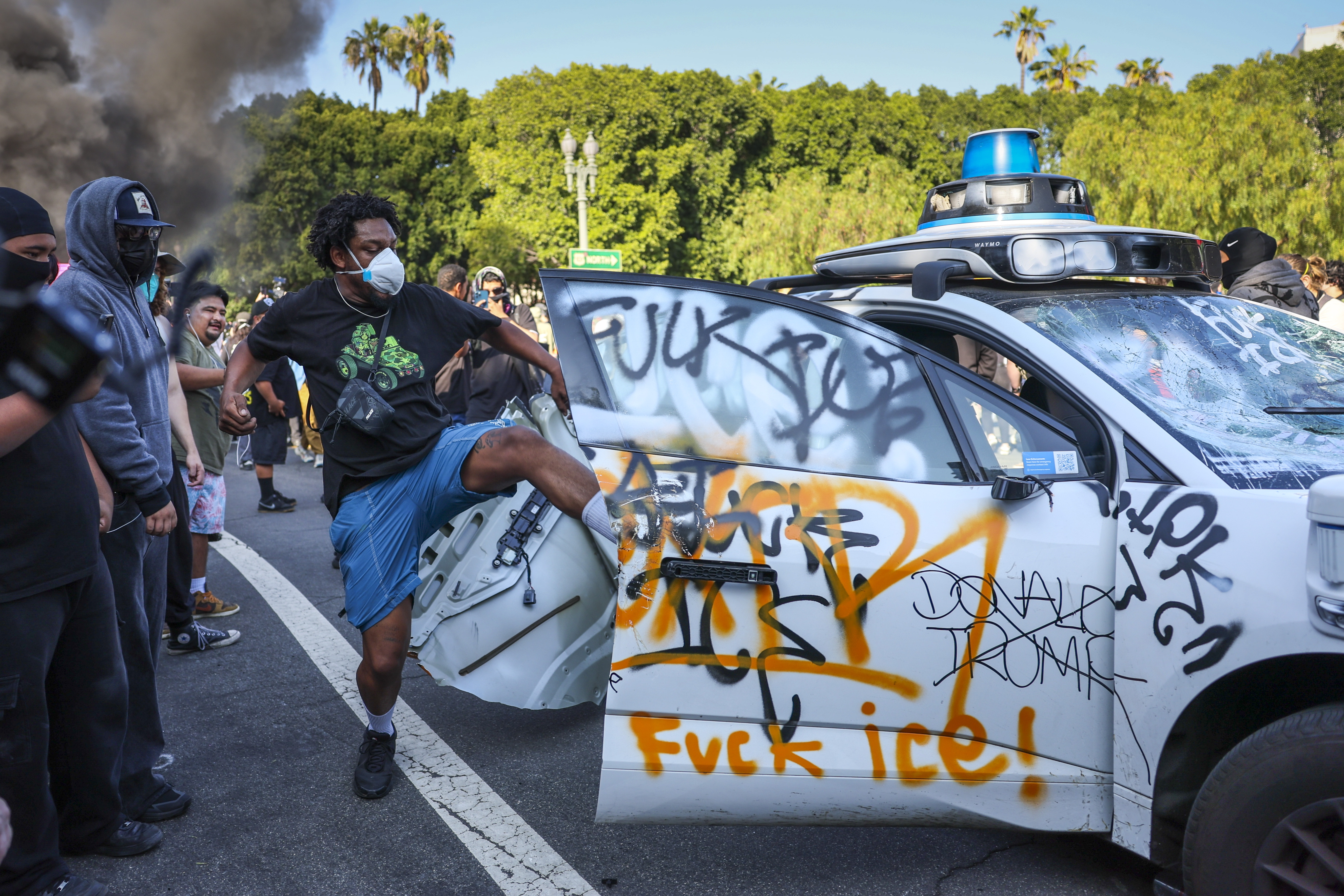 Un manifestante destroza un vehículo,  durante las protestas contra las redadas migratorias en Los Ángeles, California, EE. UU. (Foto Prensa Libre: EFE)
