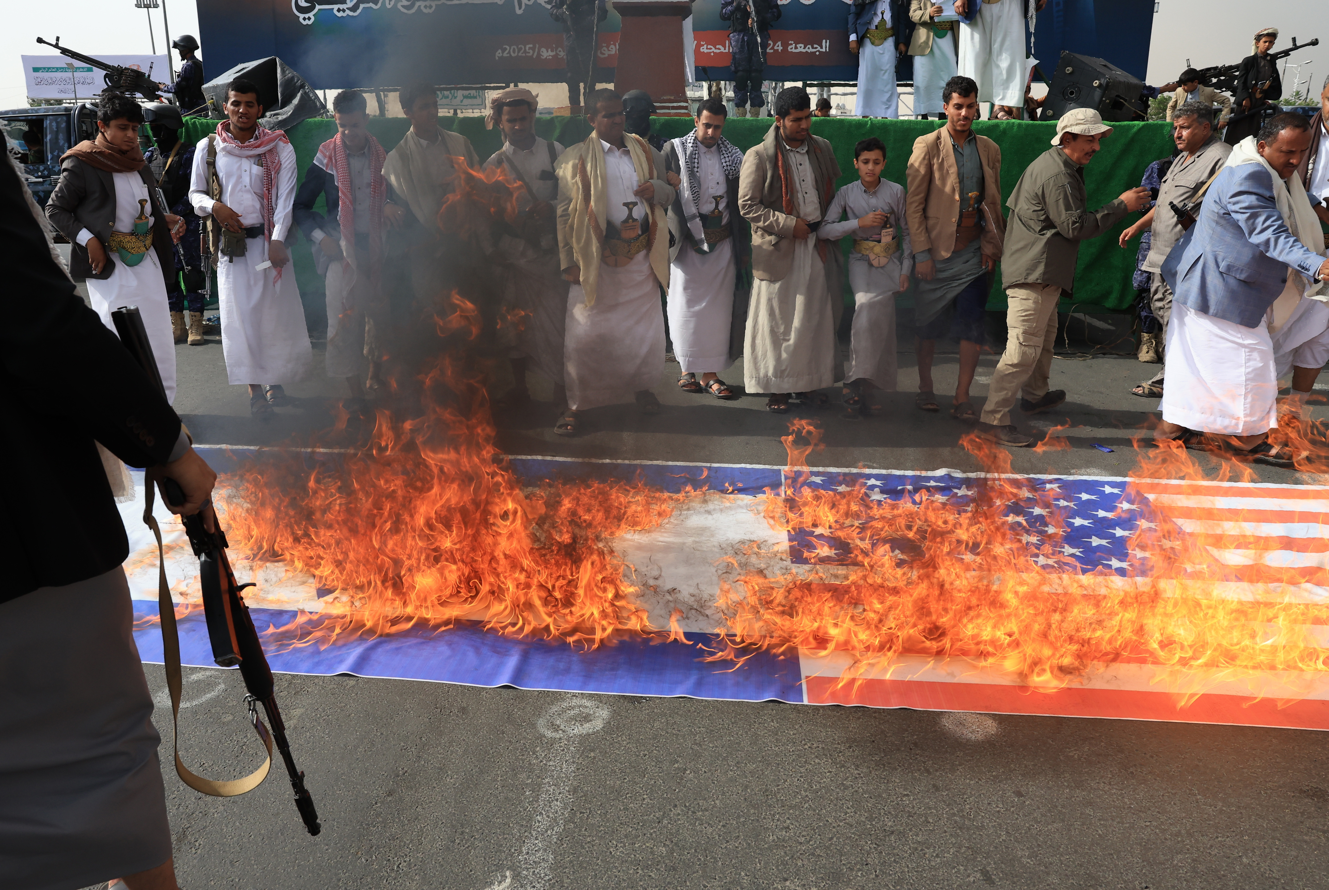 Protestantes hutíes queman banderas estadounidenses e israelíes durante una protesta en contra del conflicto, en Saná, Yemen. (Foto Prensa Libre: EFE)
