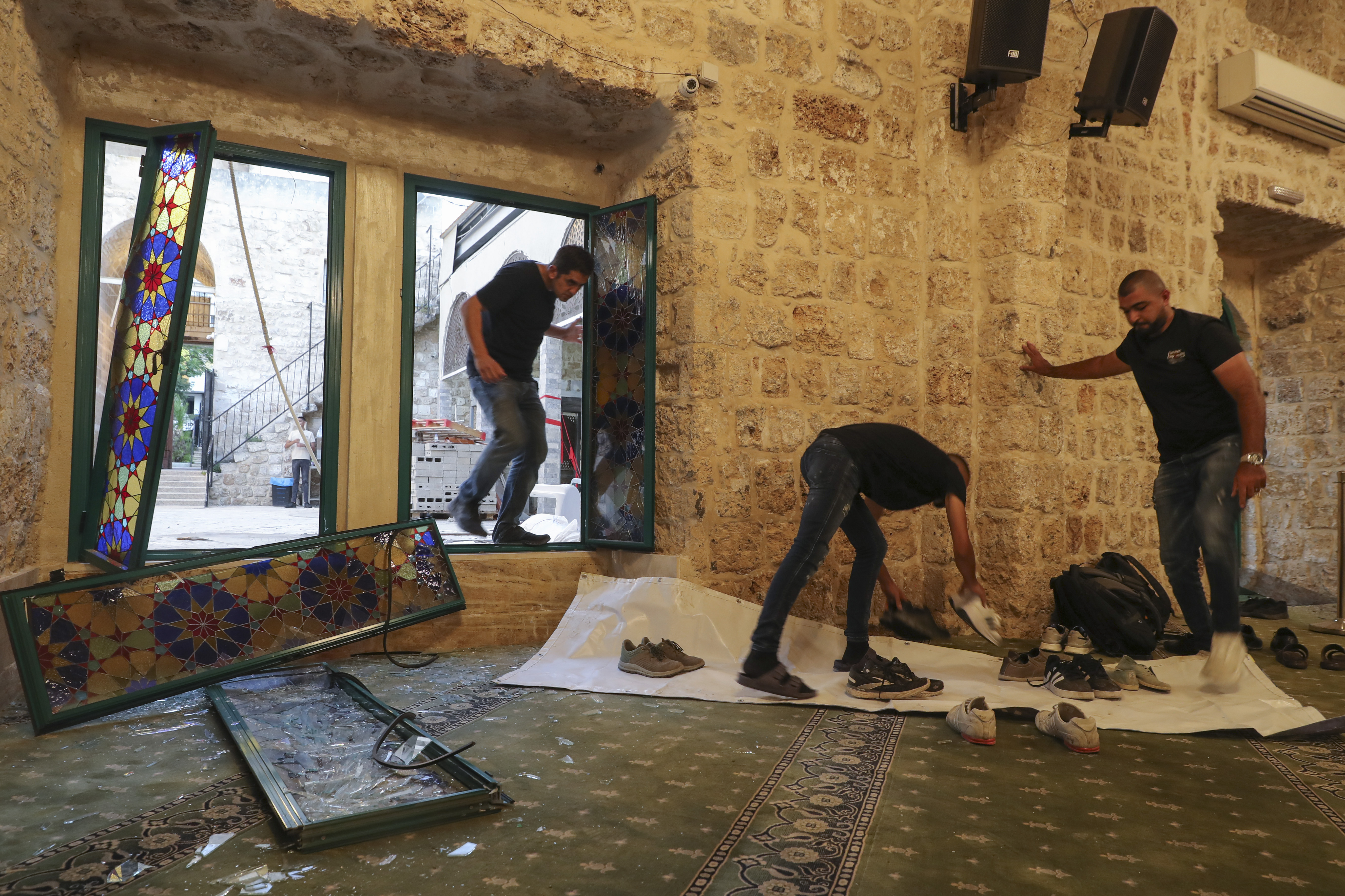 Personas verifican los daños, sobre los escombros causados por los ataques, de Irán en Israel. (Foto Prensa Libre: EFE) 