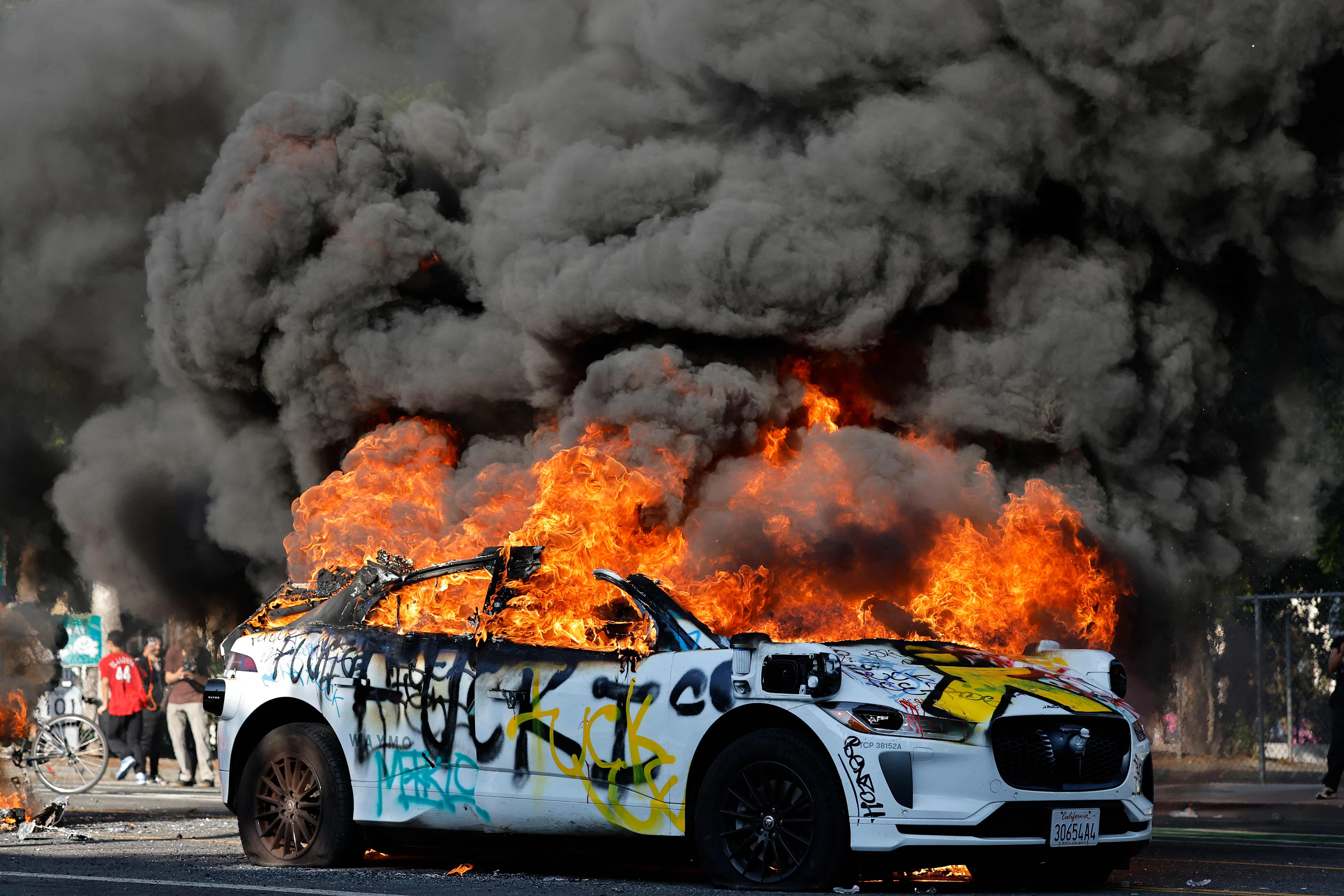 Manifestantes queman vehículos en Los Ángeles, durante la jornada de protestas en contra de las redadas.  (Foto Prensa Libre: AFP)