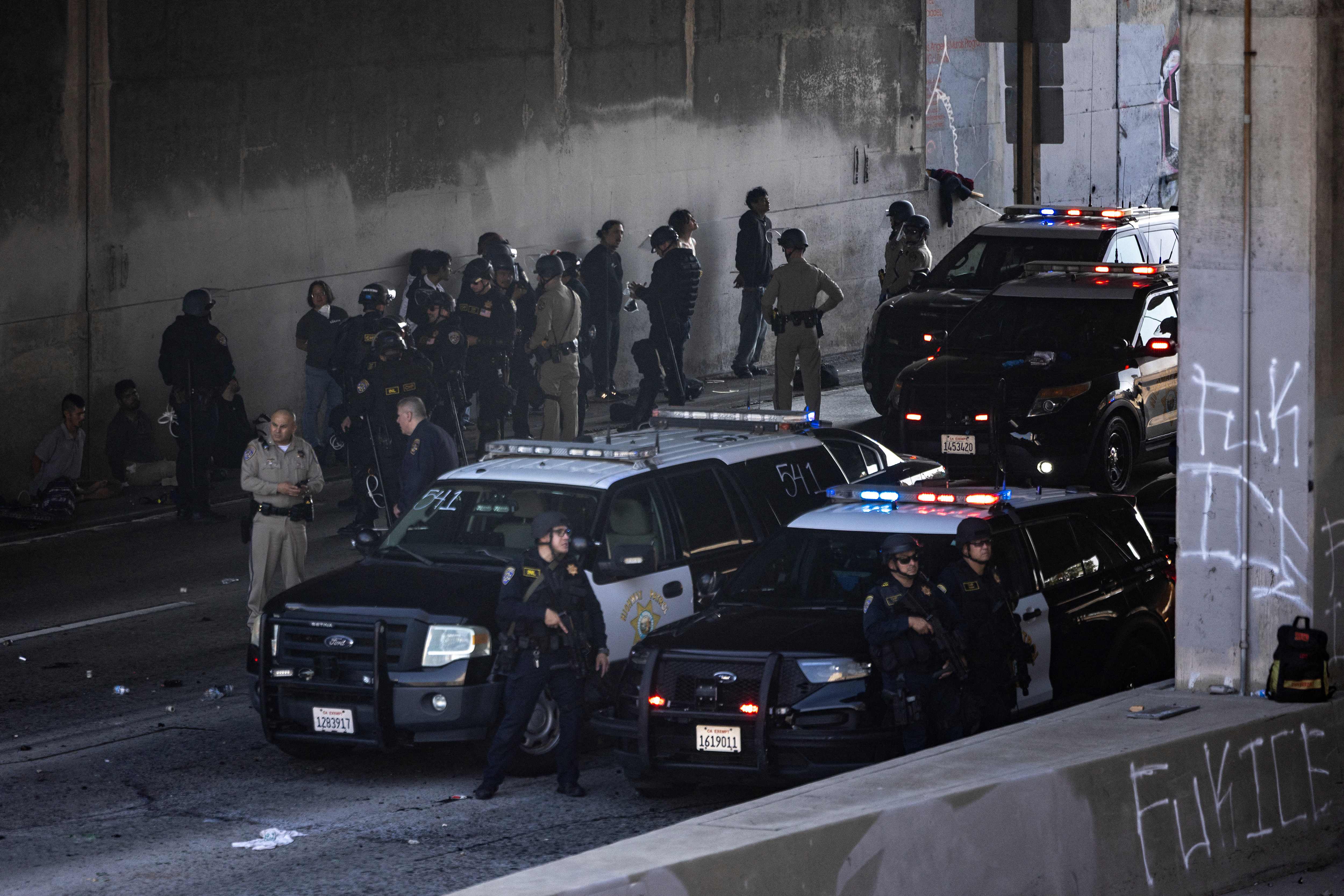 Manifestantes son detenidos por las fuerzas del orden en la autopista , mientras se enfrentan con las fuerzas del orden , tras los operativos federales de inmigración en Los Ángeles, California. (Foto Prensa Libre: AFP)