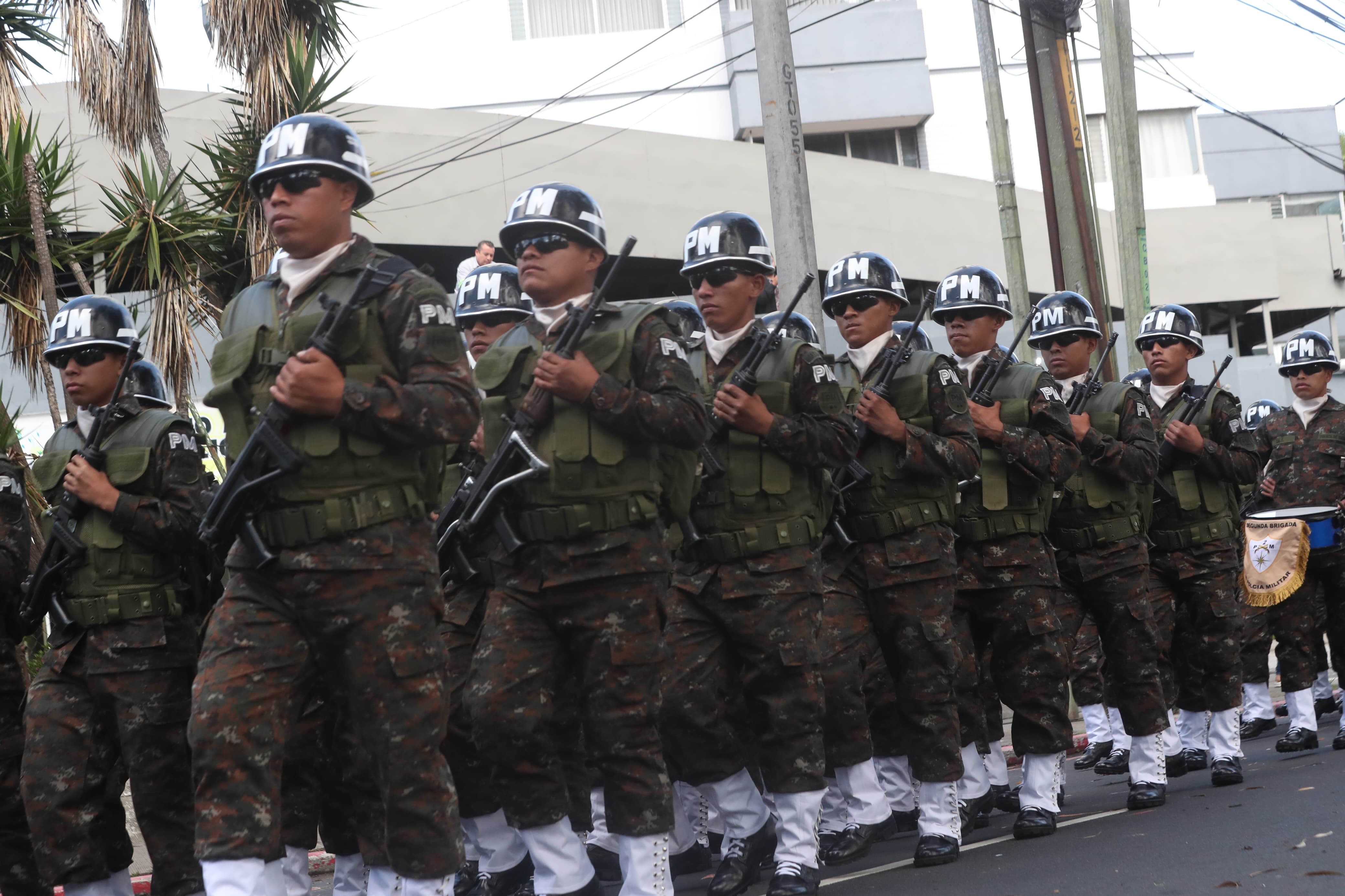 Uniformados de la Policía Militar desfilan en formación con equipamiento táctico.
