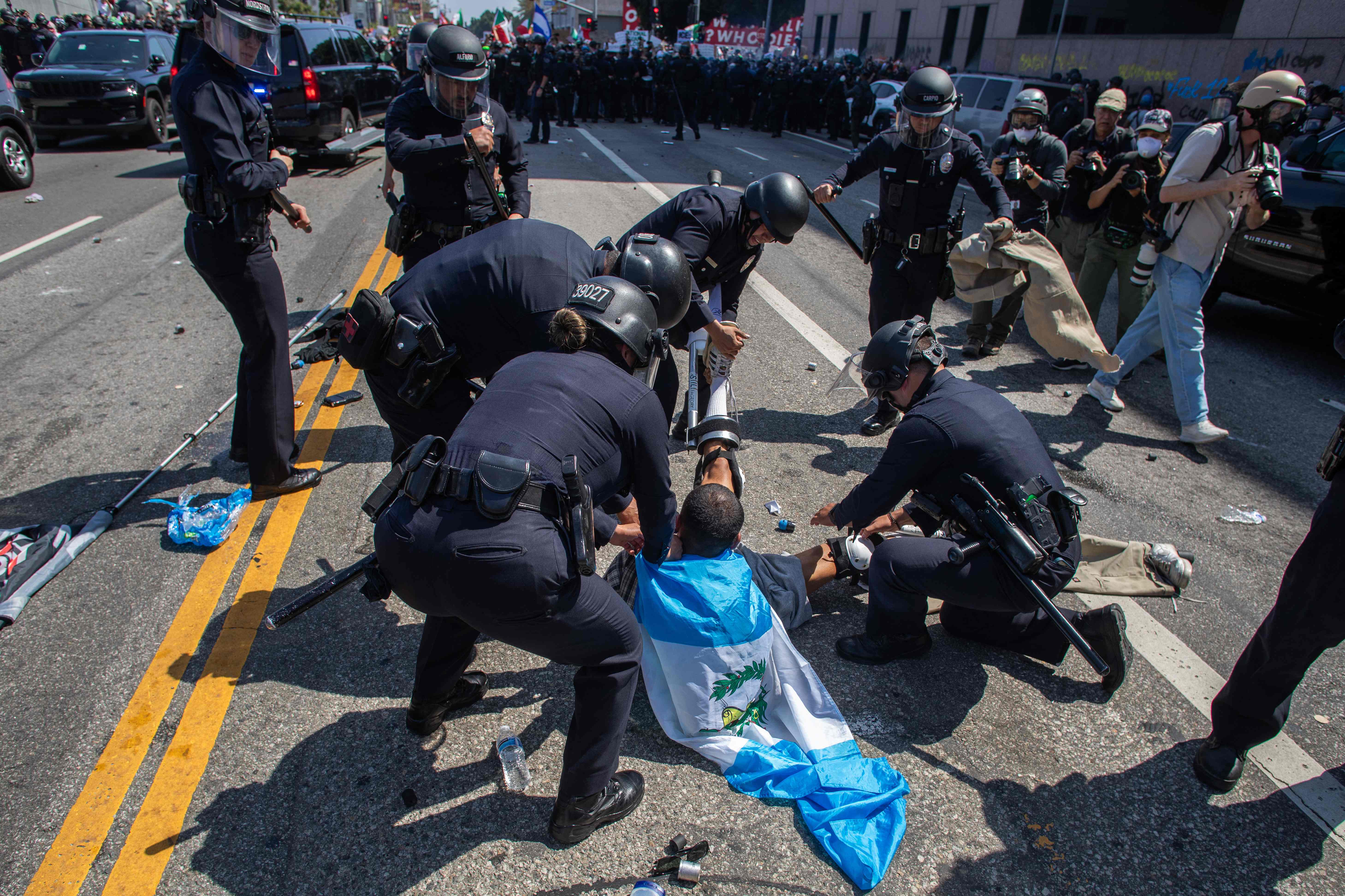 LOS ANGELES, CALIFORNIA - JUNE 08: Los Angeles Police Department officers arrest a protester in front of the LA Federal Building on June 08, 2025 in Los Angeles, California. Tensions in the city remain high after the Trump administration called in the National Guard against the wishes of city leaders following two days of clashes with police during a series of immigration raids. More protests are scheduled for today.   Apu Gomes/Getty Images/AFP (Photo by Apu Gomes/Getty Images) (Photo by Apu Gomes / GETTY IMAGES NORTH AMERICA / Getty Images via AFP)