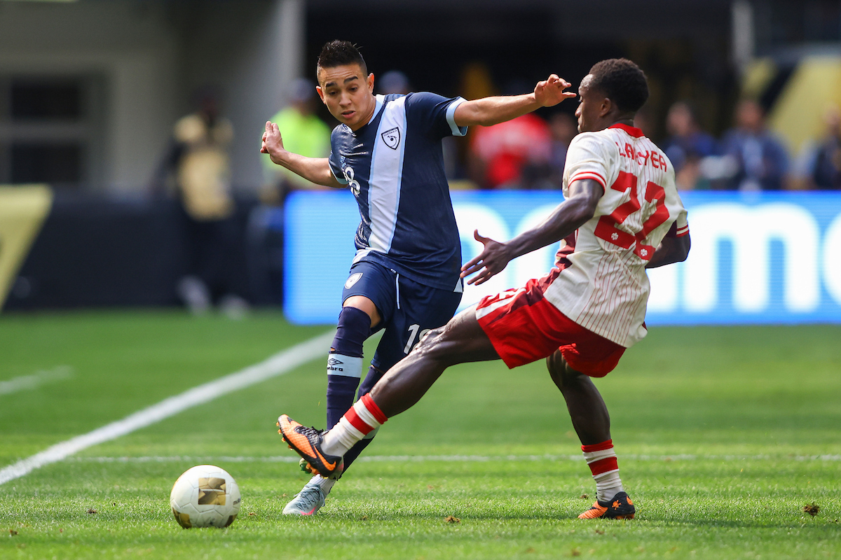 Óscar Santis de Guatemala compite por el balón con Richie Laryea de Canadá.