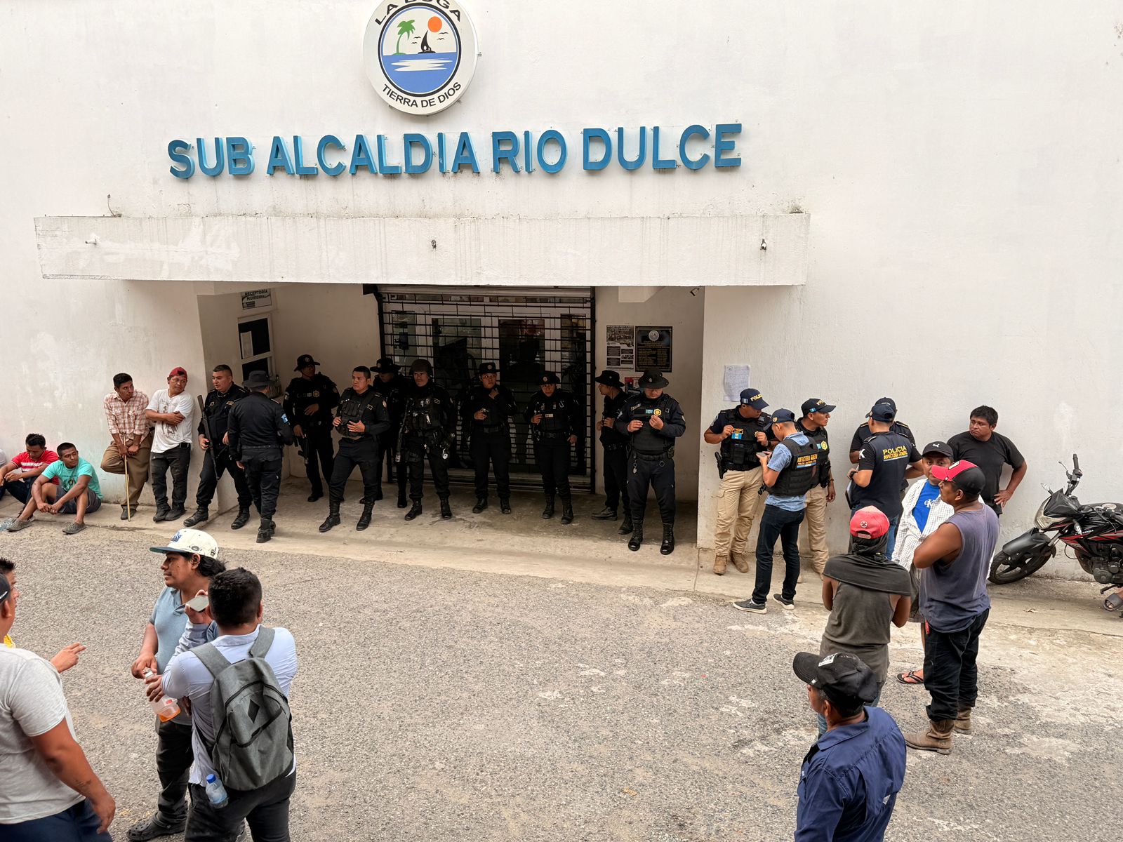 Agentes de la Policia Nacional Civil (PNC), resguardan la entrada principal de la sub alcaldía de Río Dulce, ya que manifestantes enfurecidos rodean el lugar. (Foto Prensa Libre: Joseph Domínguez)