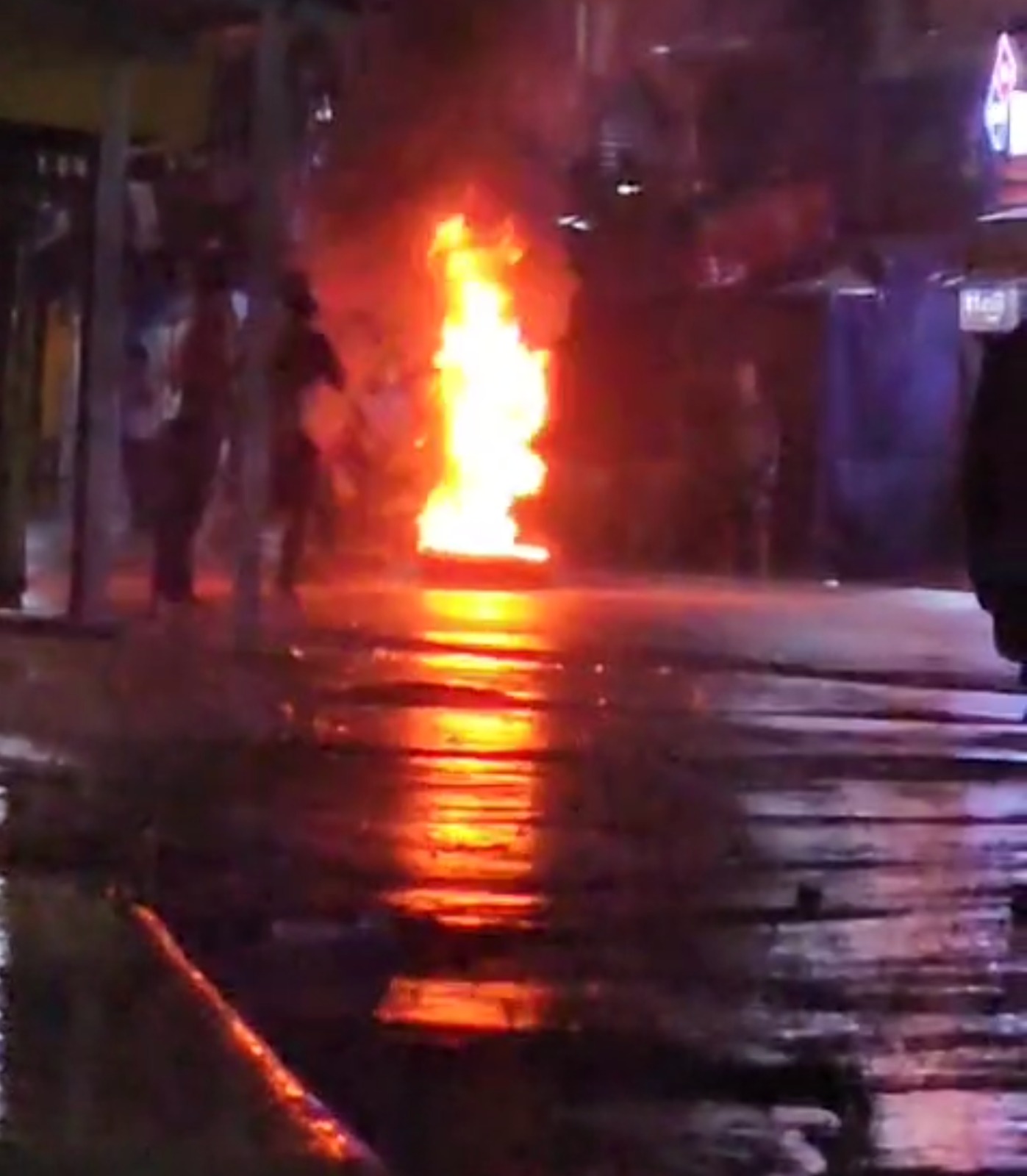 Pobladores que manifiestan en contra de la minería, inician a quemar llantas, agentes antimotines se hicieron presentes en el lugar para dispersar a las personas. (Foto Prensa Libre: Captura de pantalla de video)