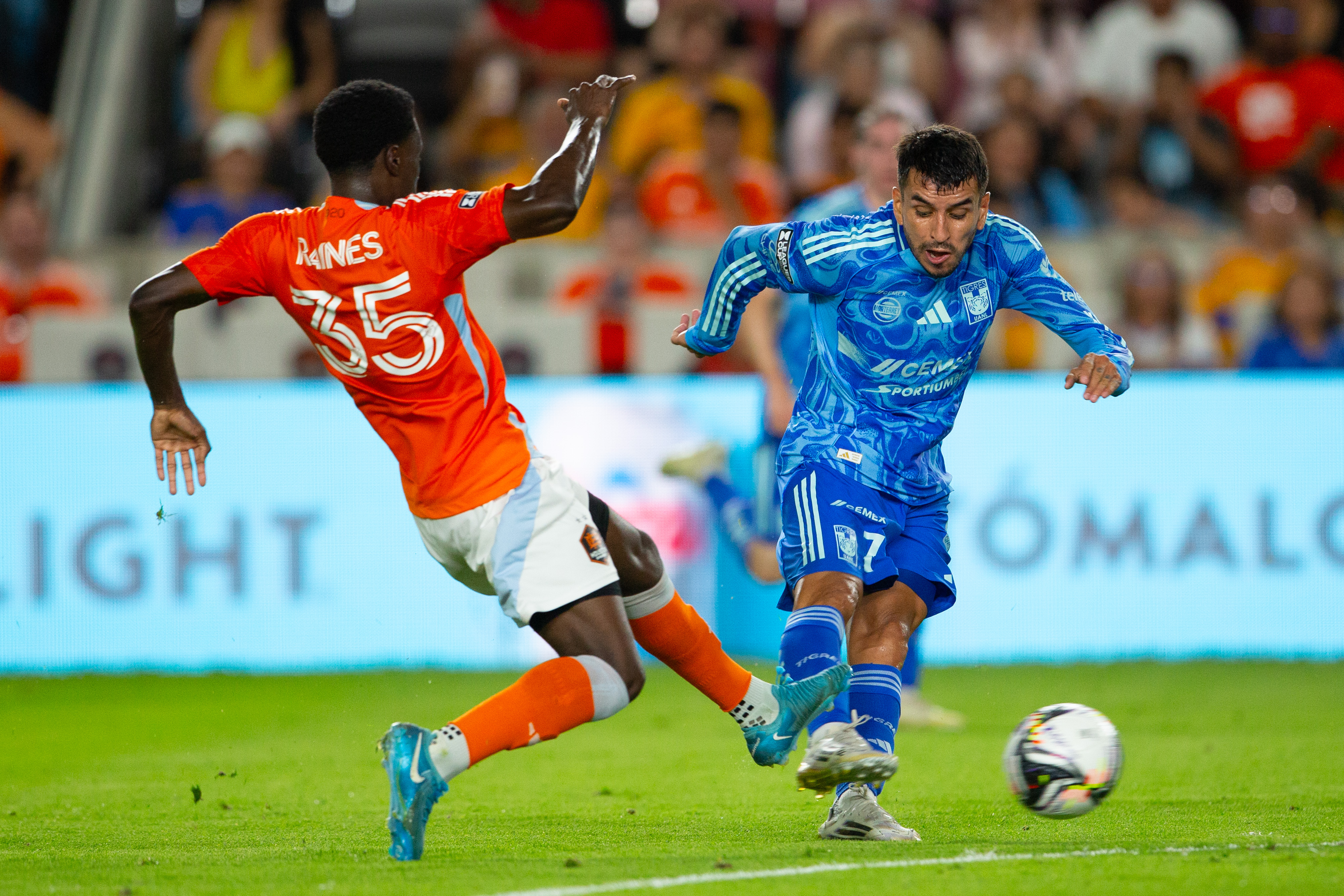 Ángel Correa (d) de Tigres disputa el balón con Brooklyn Raines de Dynamo