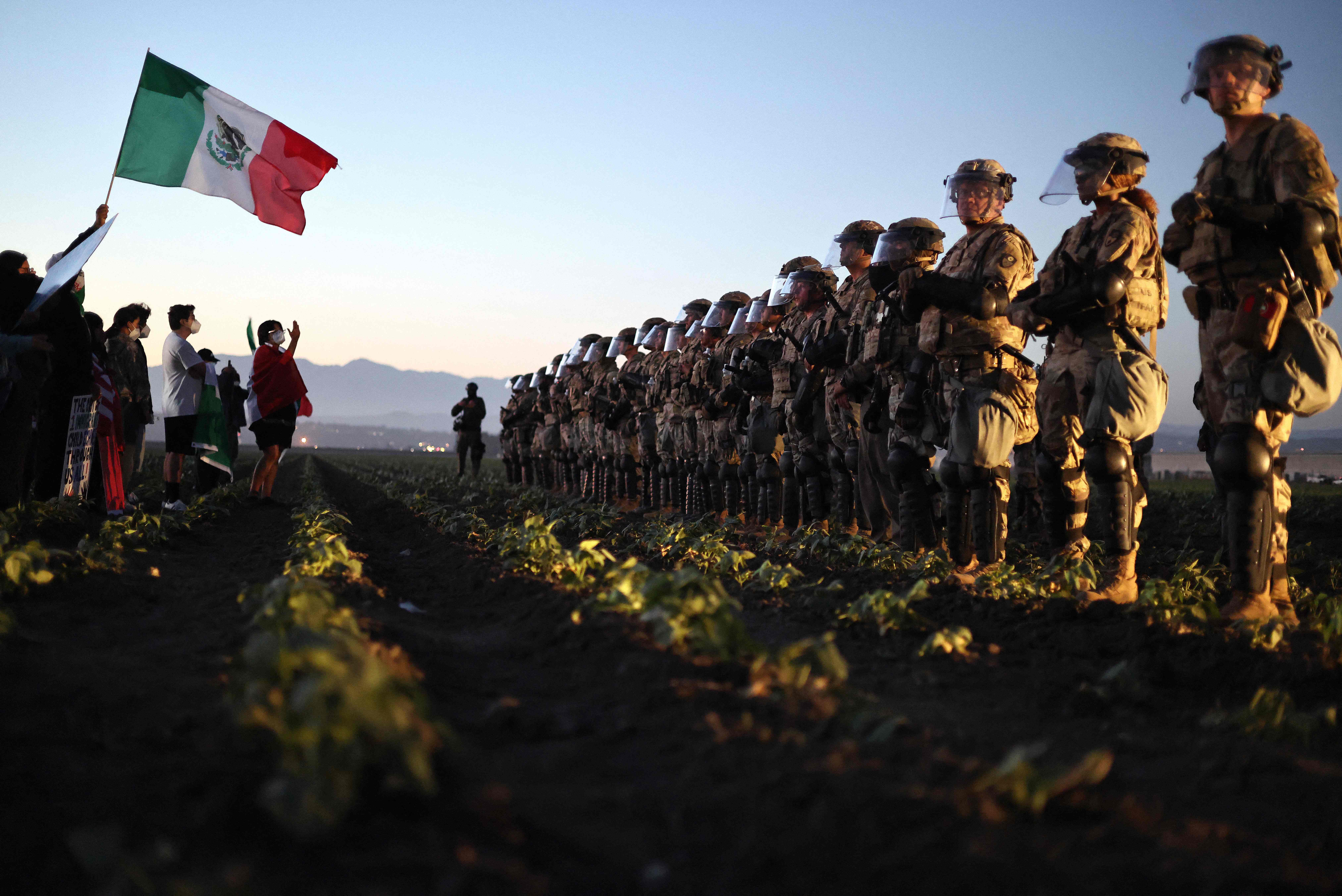 CAMARILLO, CALIFORNIA - JULY 10: National Guard soldiers block protestors during an ICE immigration raid at a nearby cannabis farm on July 10, 2025 near Camarillo, California. Protestors stood off with federal agents for hours outside the farm in the farmworker community in Ventura County. A Los Angeles federal judge is set to rule Friday on a temporary restraining order which would restrict area immigration enforcement operations.   Mario Tama/Getty Images/AFP (Photo by MARIO TAMA / GETTY IMAGES NORTH AMERICA / Getty Images via AFP)