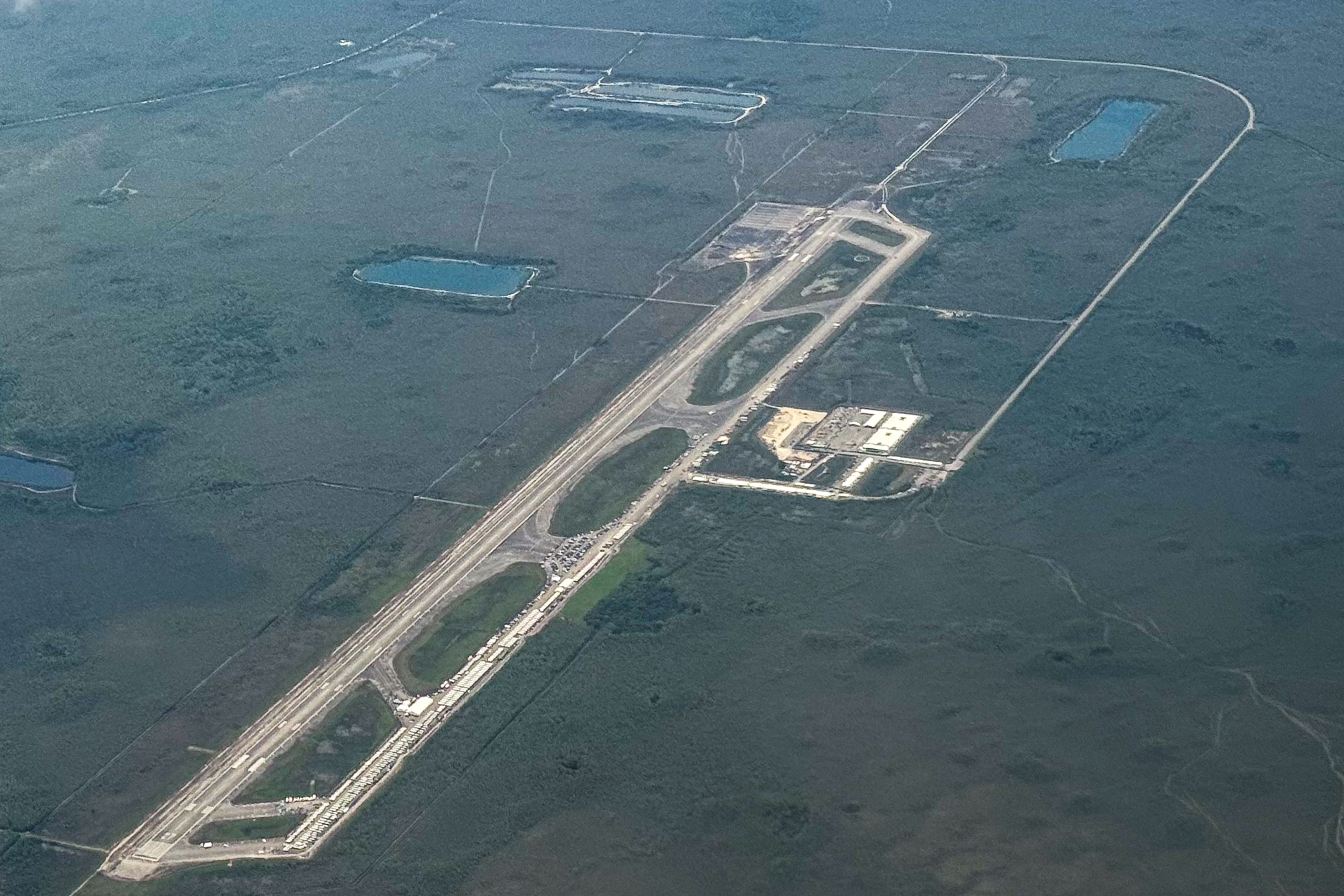 TOPSHOT - An ariel view of a migrant detention center, dubbed "Alligator Alcatraz," is seen located at the site of the Dade-Collier Training and Transition Airport in Ochopee, Florida on July 7, 2025. The $450 million camp has been built on a disused airfield deep in the Florida Everglades and is surrounded by swamps that are home to creatures including alligators and poisonous snakes. The steaming hot, mosquito-infested site is a symbol of the Republican administration's determination to look tough as it pursues its policy of mass deportations of undocumented migrants. (Photo by CHANDAN KHANNA / AFP)