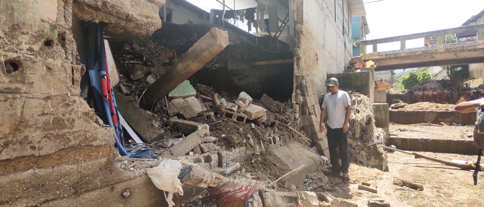 Vecinos de la colonia Progreso 2 abren un boquete en una pared para evacuar el agua acumulada tras el desborde de un arroyo. (Foto Prensa Libre: Andrea Domínguez)