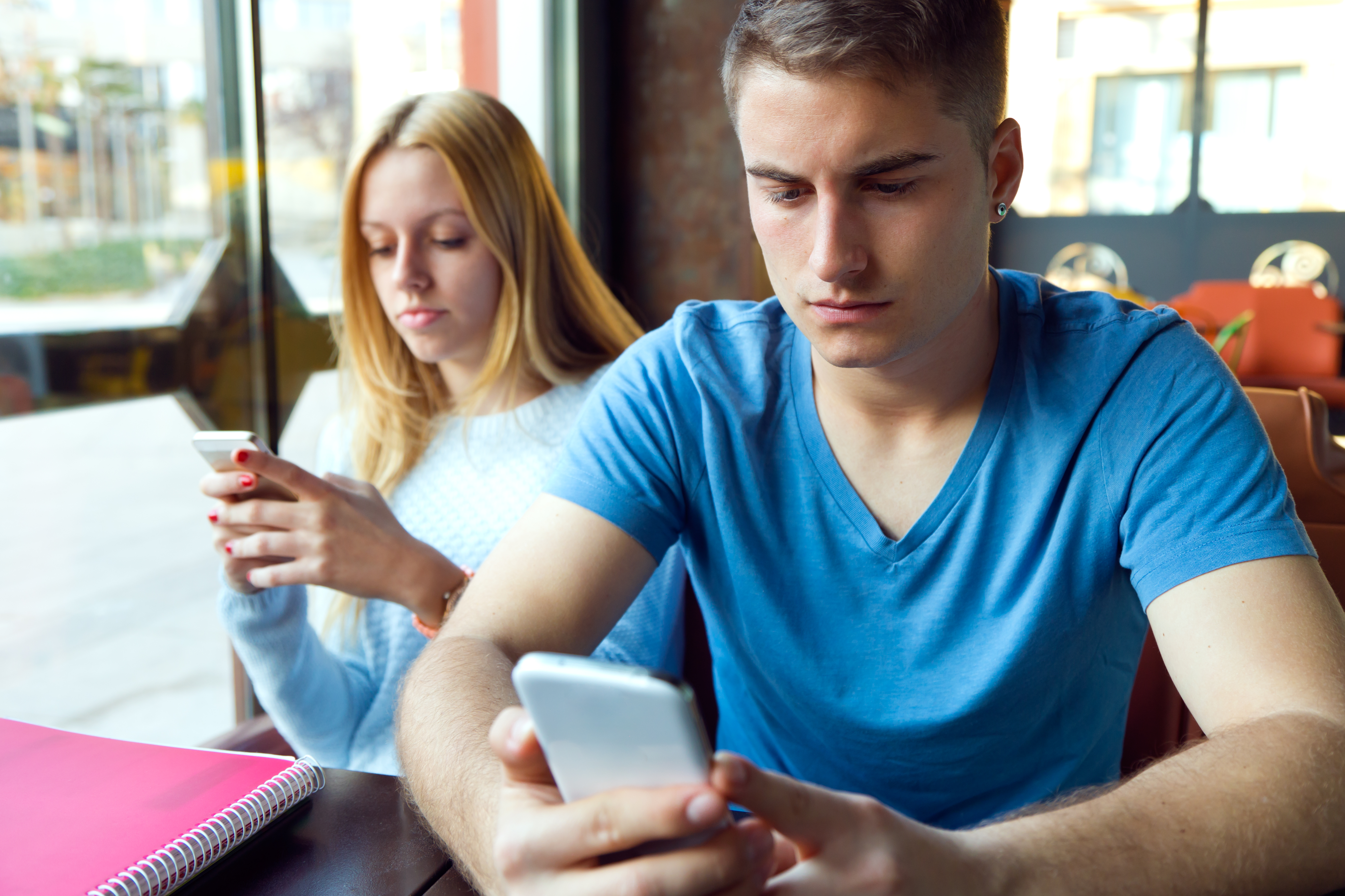 Portrait of group of friends using mobile phone in cafe.