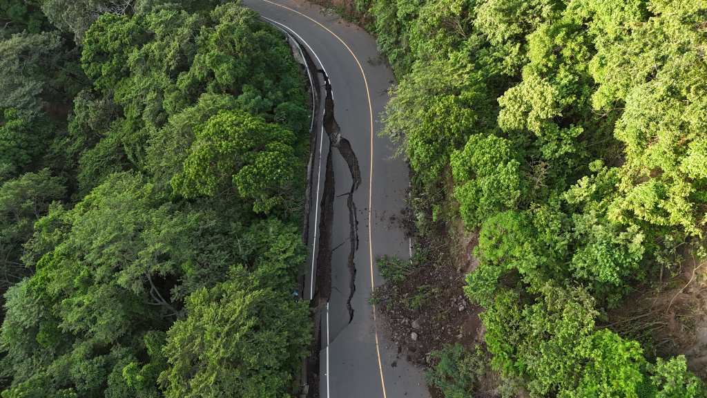 Socavón profundo en la carretera que conecta Santa María de Jesús con Palín, mostrando el daño en el asfalto y el borde colapsado.