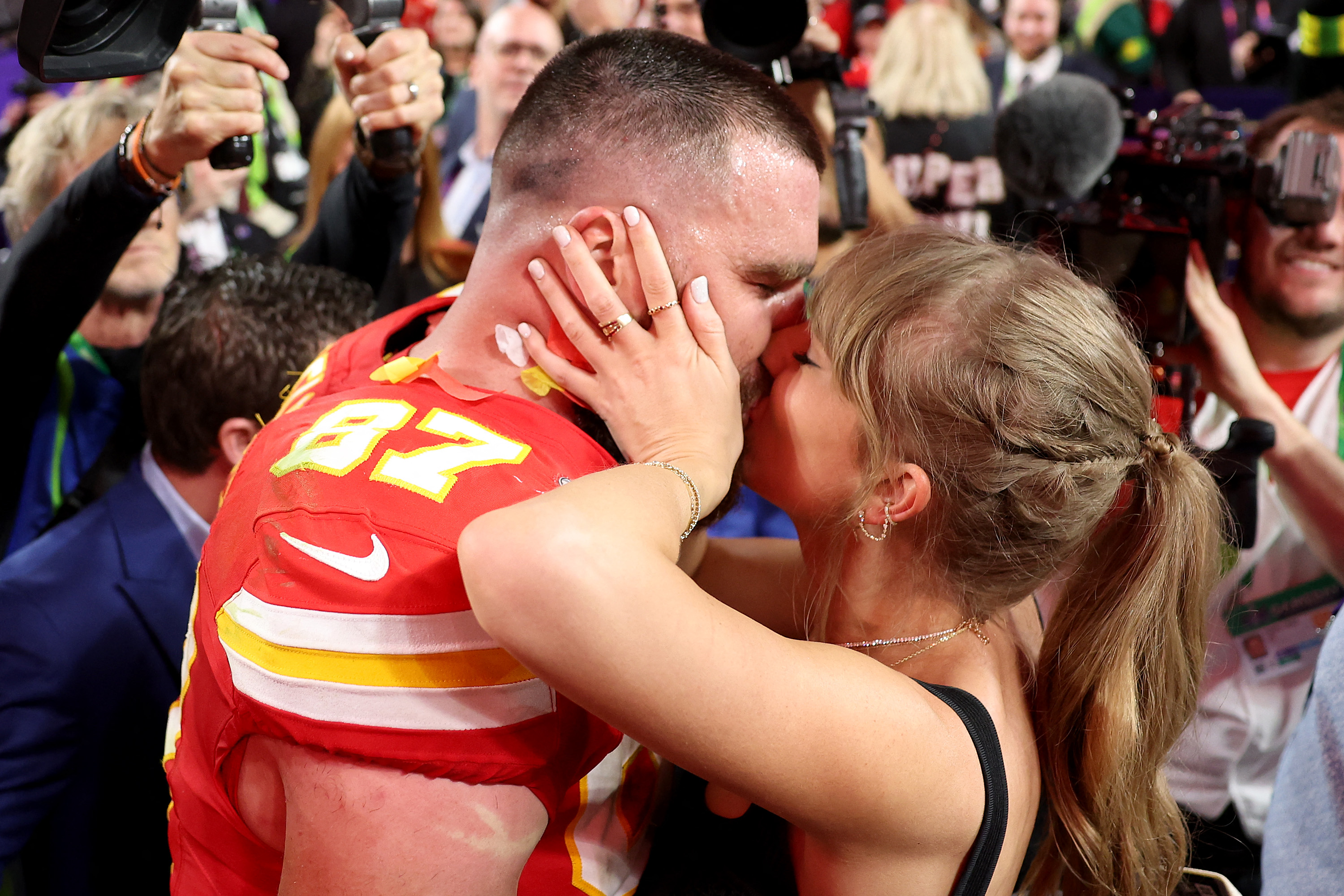 (FILES) Travis Kelce #87 of the Kansas City Chiefs kisses Taylor Swift after defeating the San Francisco 49ers 25-22 in overtime during Super Bowl LVIII at Allegiant Stadium on February 11, 2024 in Las Vegas, Nevada. Pop superstar Taylor Swift and American football player Travis Kelce announced their engagement on August 26, 2025, setting the stage for a high-profile wedding for the celebrity couple. A joint post on their Instagram pages showed pictures of Kelce on one knee making his marriage proposal in a flower-laden garden, and then Swift, 35, displaying a large diamond ring. (Photo by Ezra SHAW / GETTY IMAGES NORTH AMERICA / AFP)